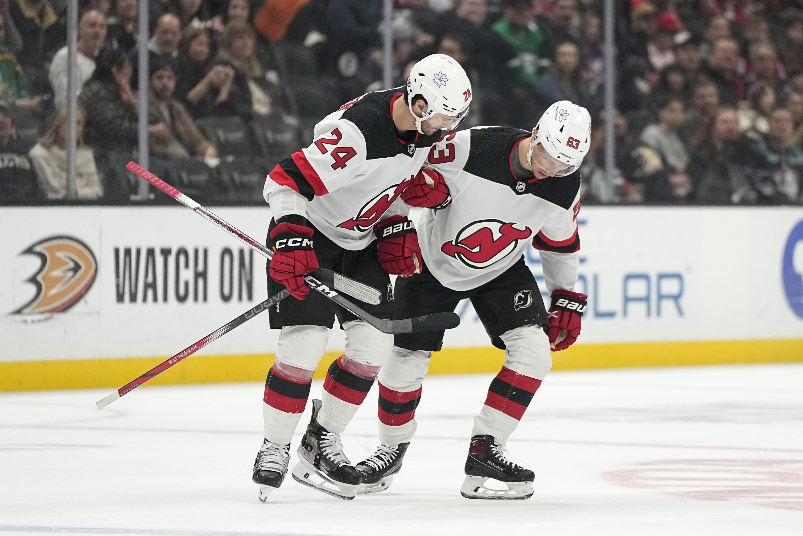 New Jersey Devils left wing Jesper Bratt, right, is helped...