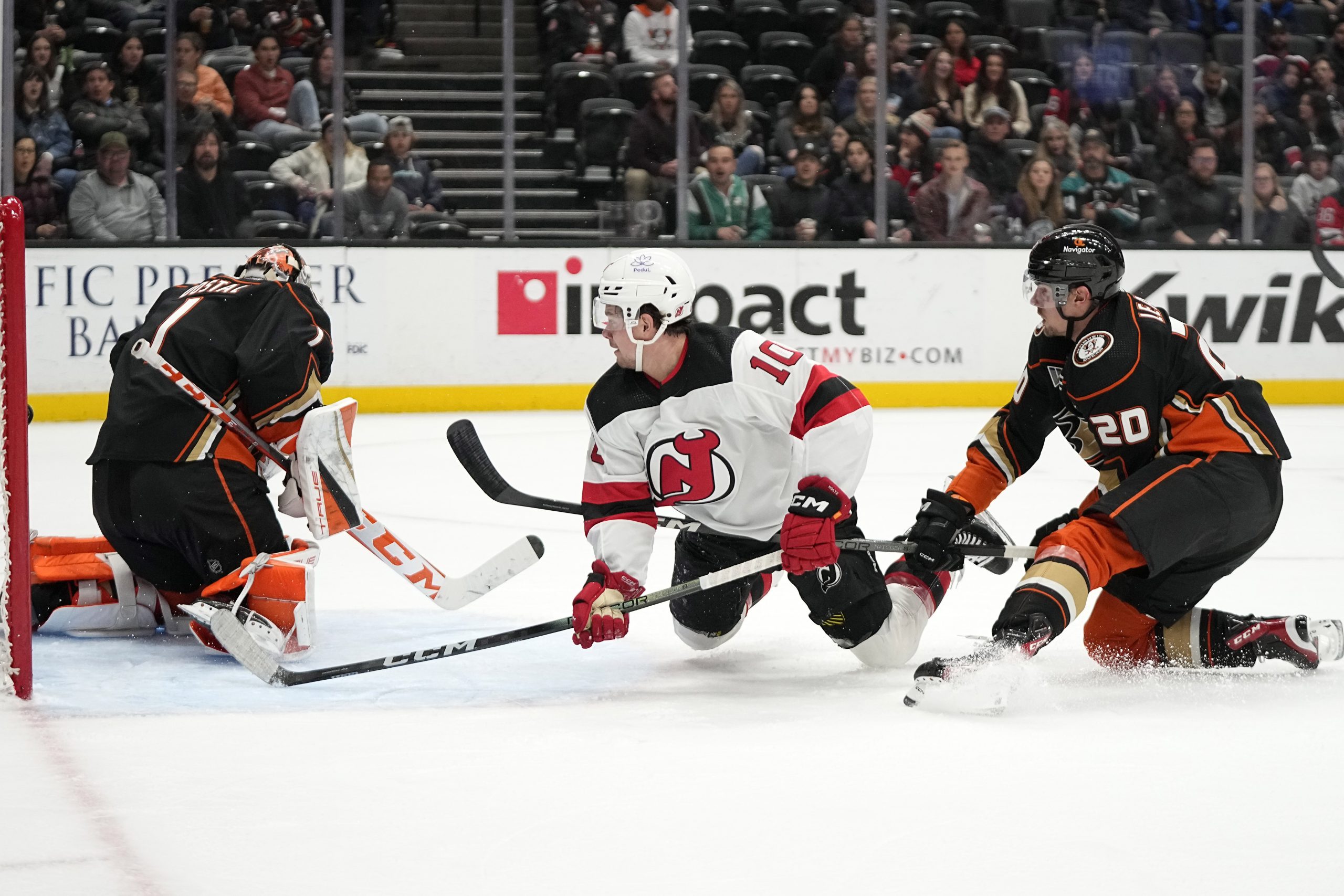 New Jersey Devils right wing Alexander Holtz, center, tires to...