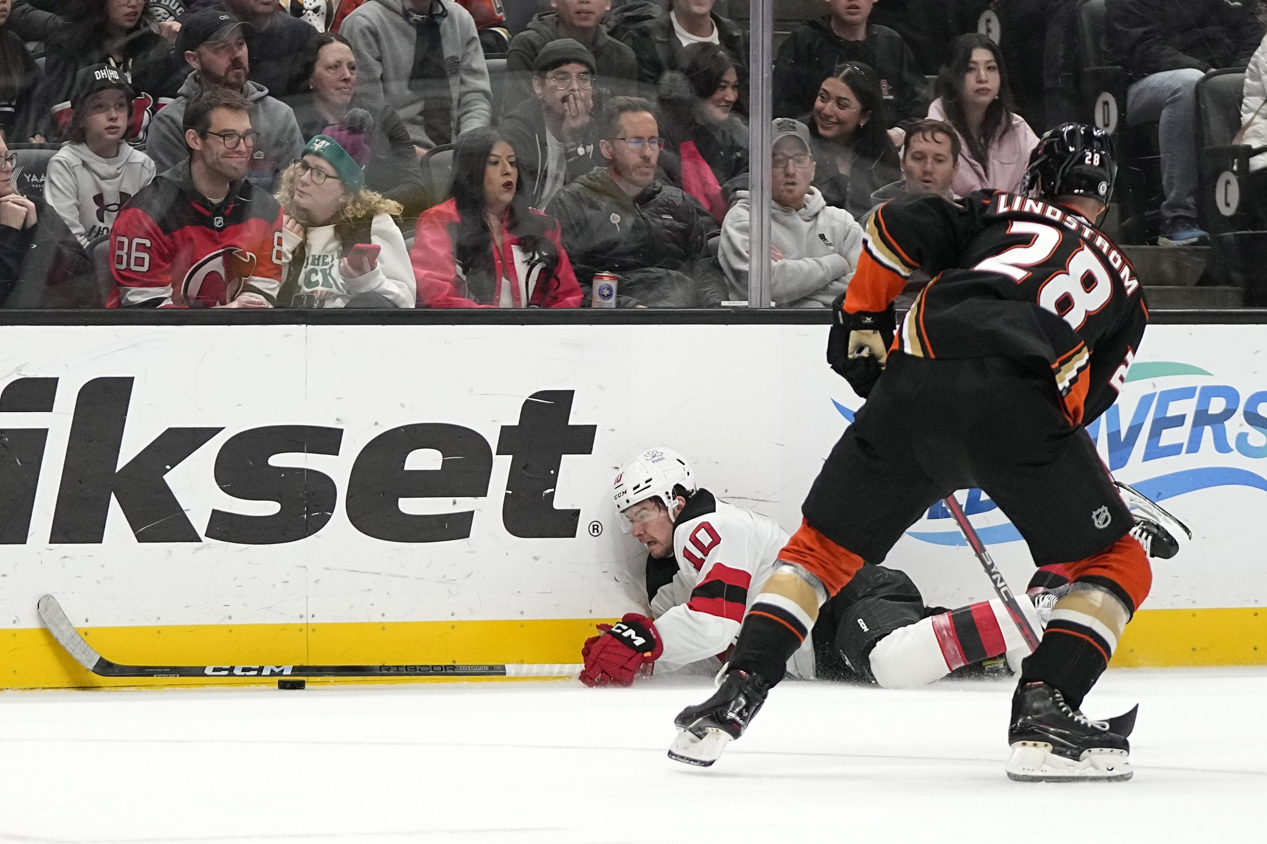 New Jersey Devils right wing Alexander Holtz, left, falls as...