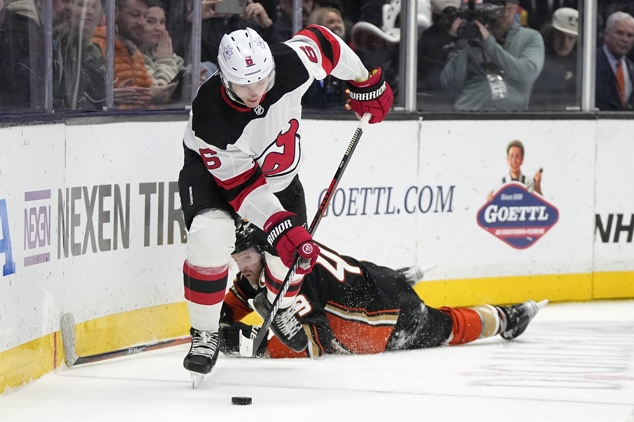 New Jersey Devils defenseman John Marino, top, takes the puck...