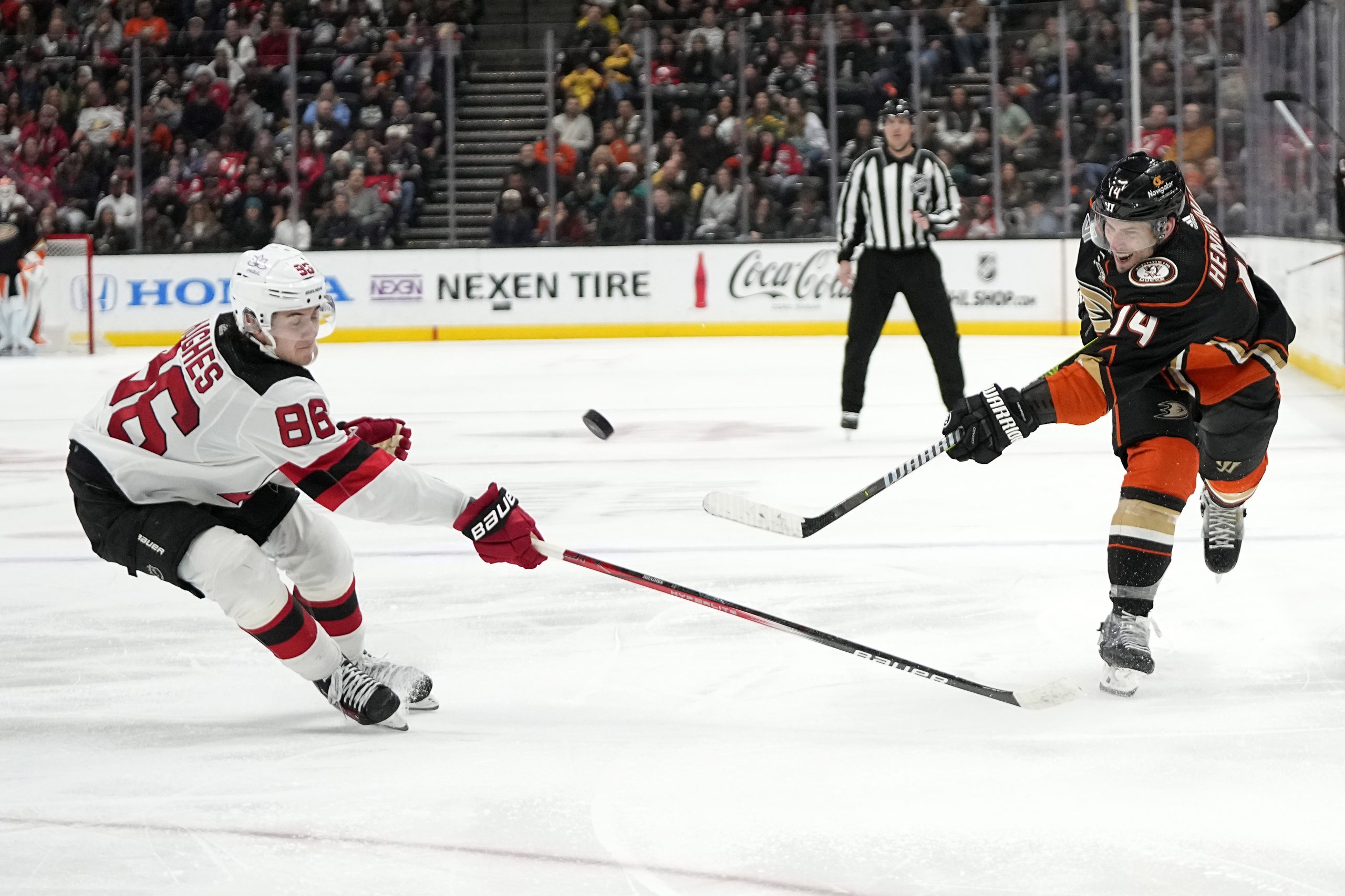 Ducks center Adam Henrique, right, shoots the puck as New...