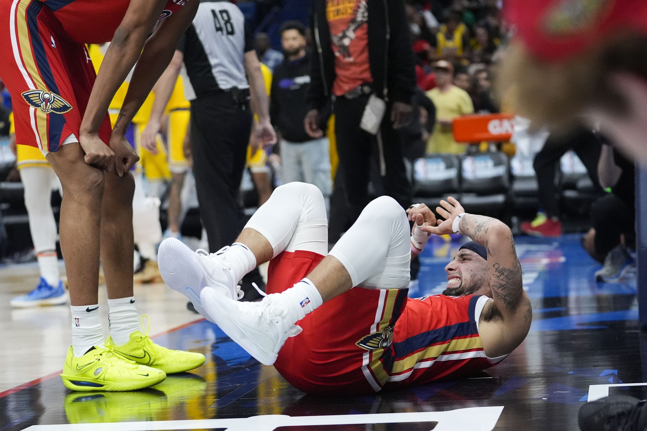 New Orleans Pelicans guard Jose Alvarado reacts after crashing to...