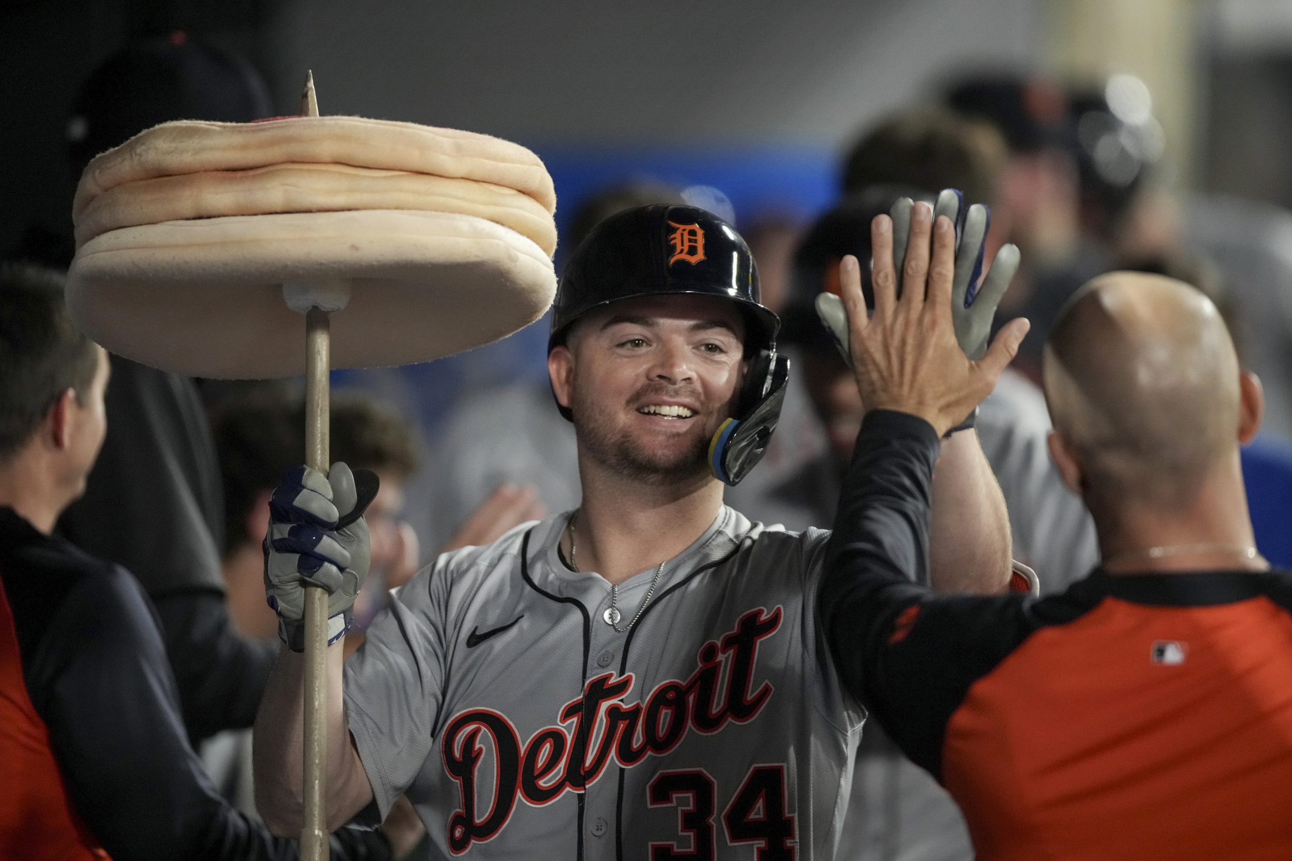 Detroit Tigers’ Jake Rogers (34) high-fives a teammate in the...
