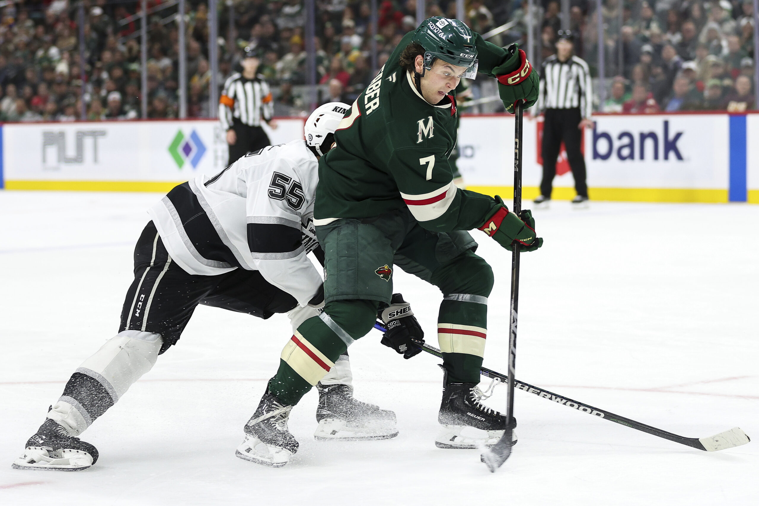 Minnesota Wild defenseman Brock Faber, right, shoots as Kings right...