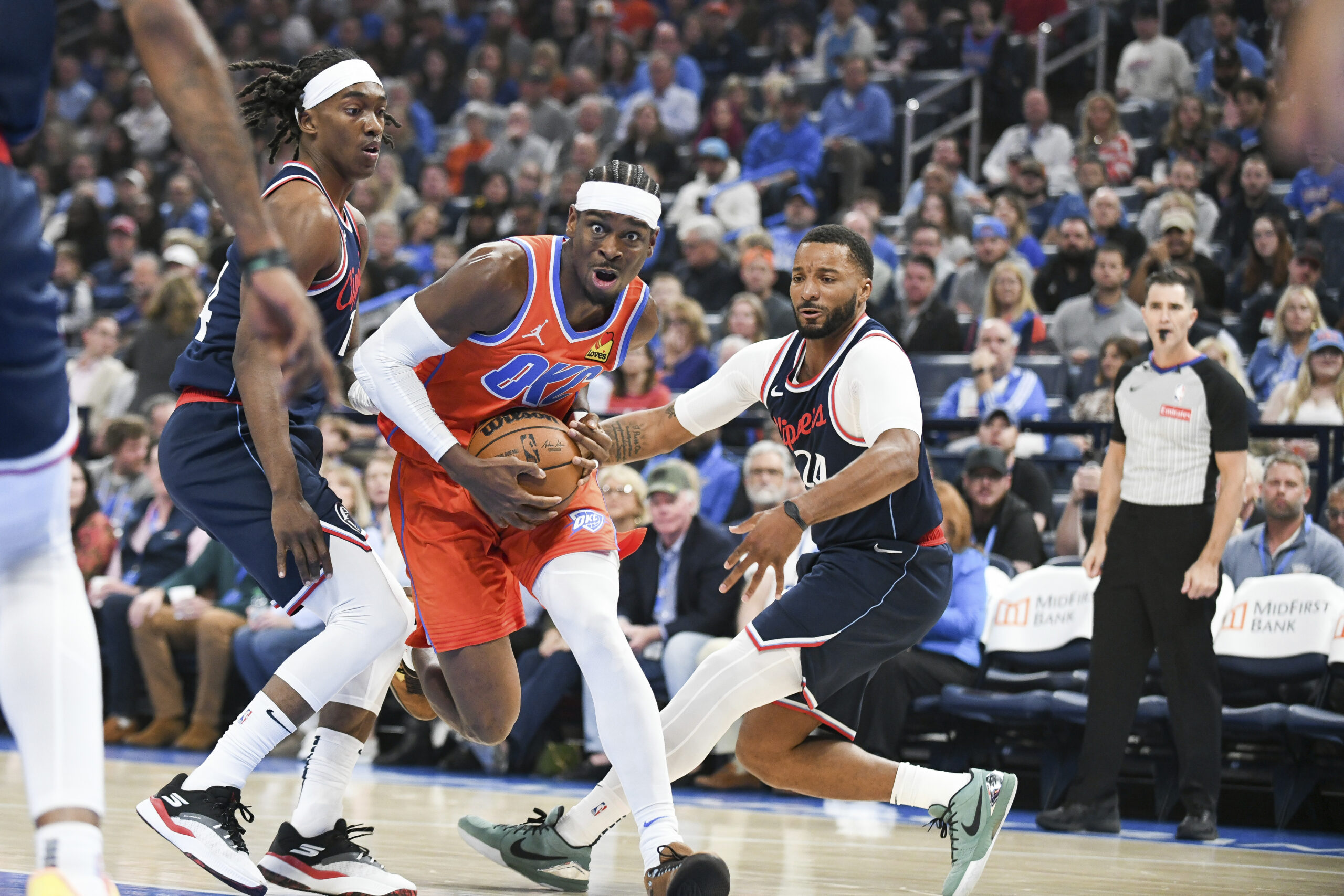 Oklahoma City Thunder guard Shai Gilgeous-Alexander, center, drives past Clippers...