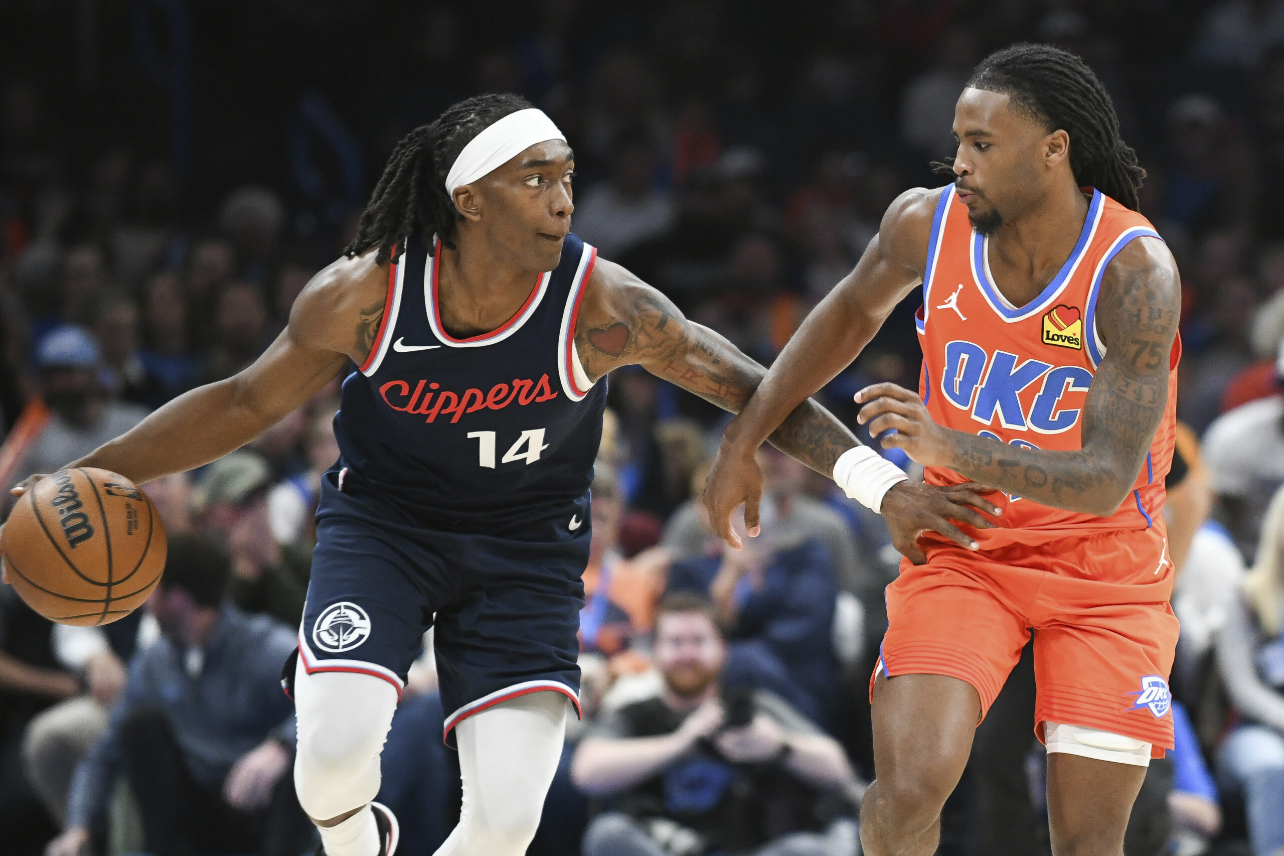 Clippers guard Terance Mann, left, pushes past Oklahoma City Thunder...