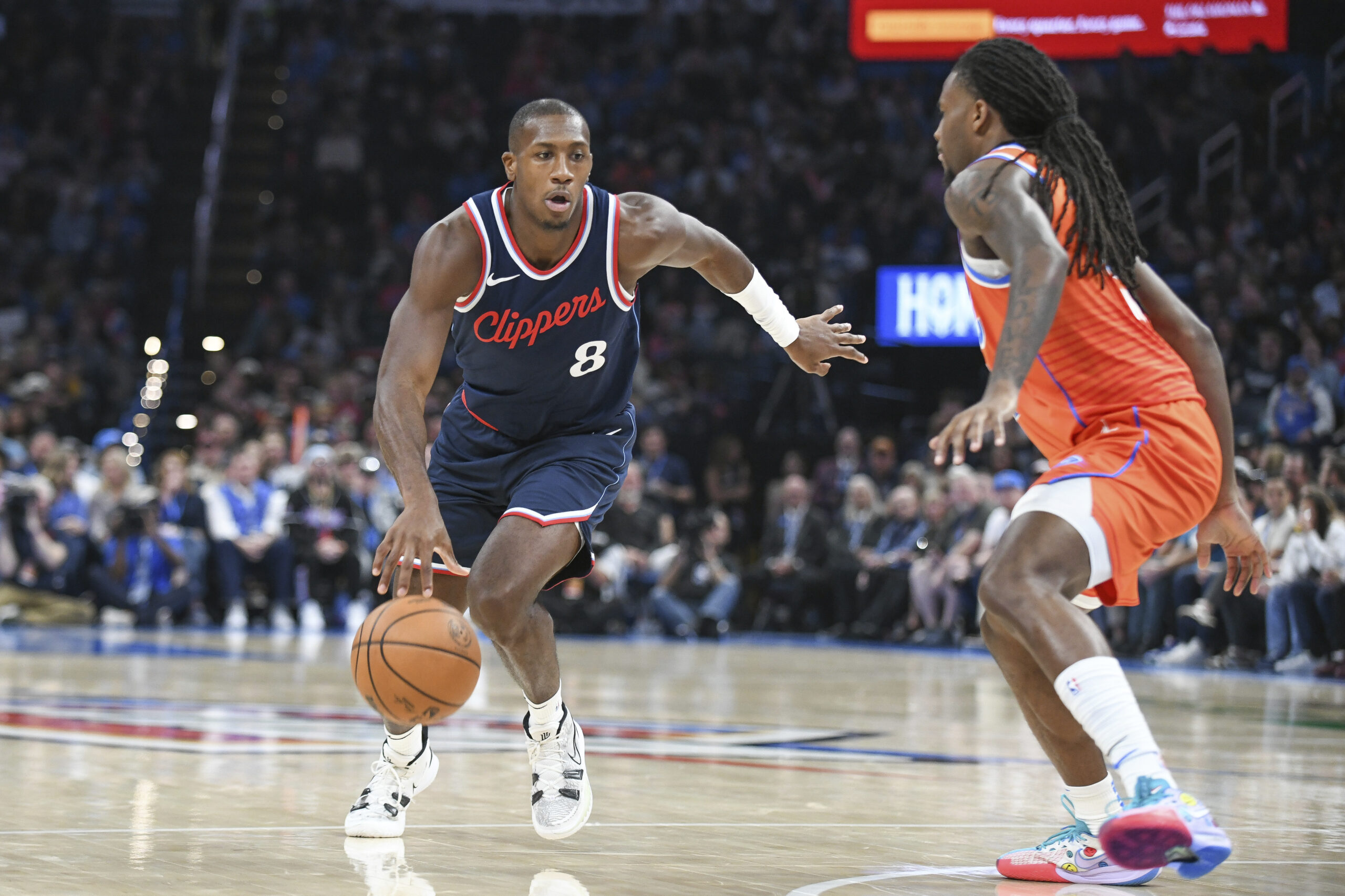 Clippers guard Kris Dunn, left, drives past Oklahoma City Thunder...