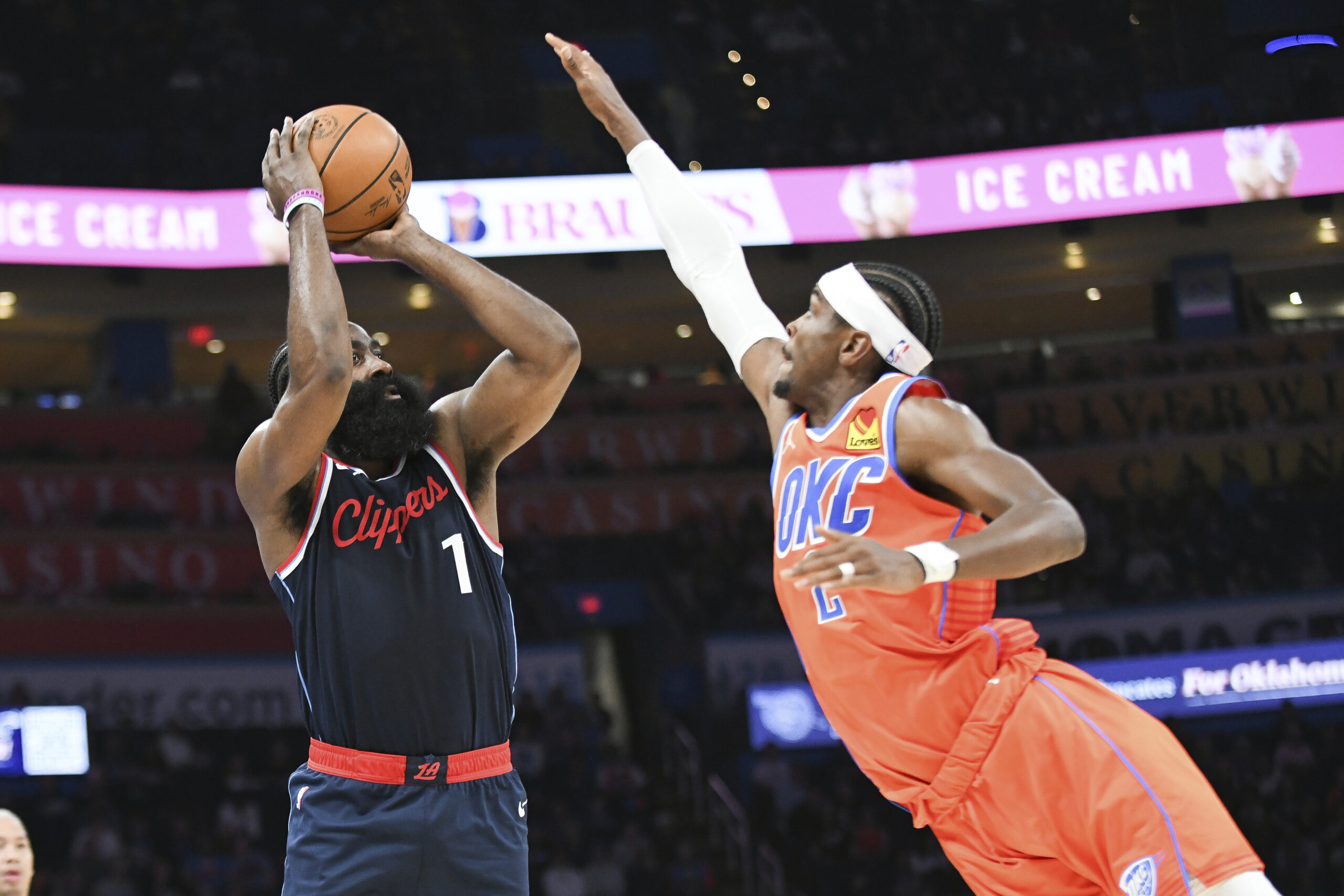 Clippers guard James Harden, left, shoots over Oklahoma City Thunder...