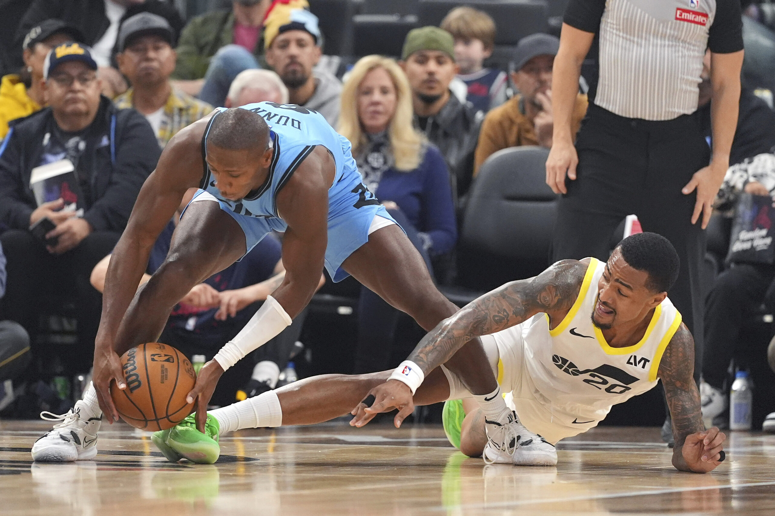 Clippers guard Kris Dunn, left, grabs a loose ball away...