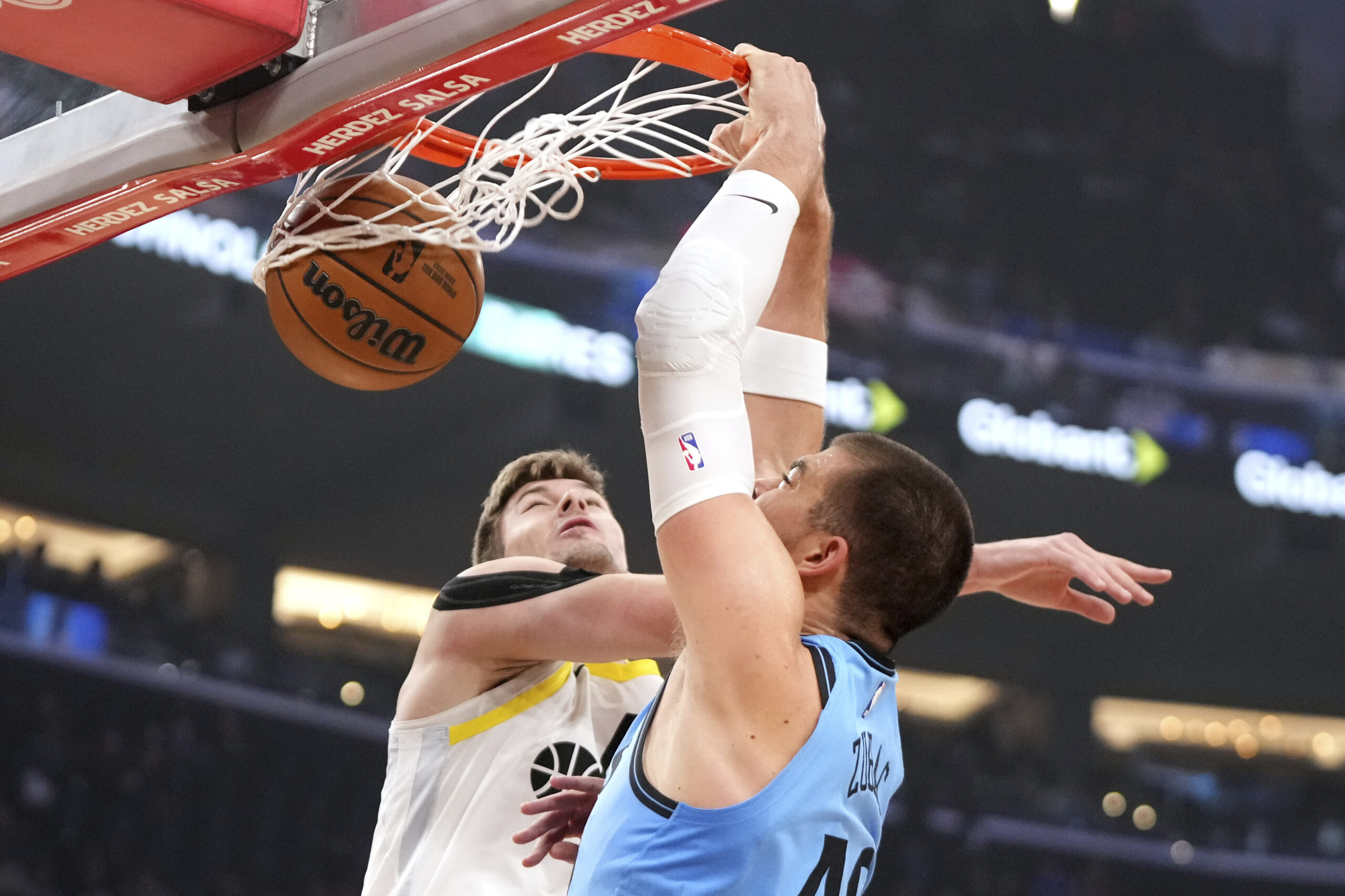 Clippers center Ivica Zubac, right, dunks as Utah Jazz forward...