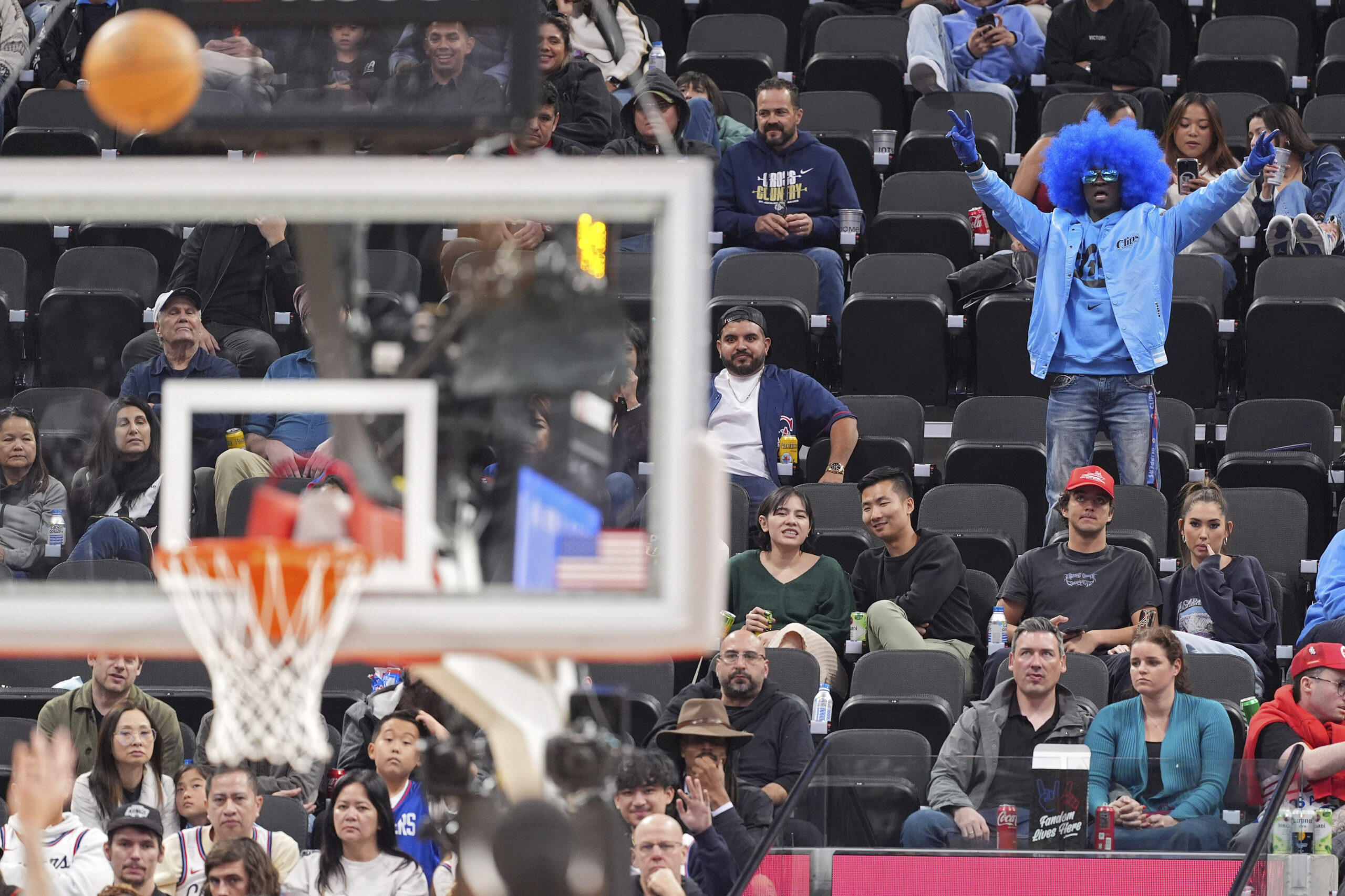 A fan cheers as a shot by Clippers guard Amir...