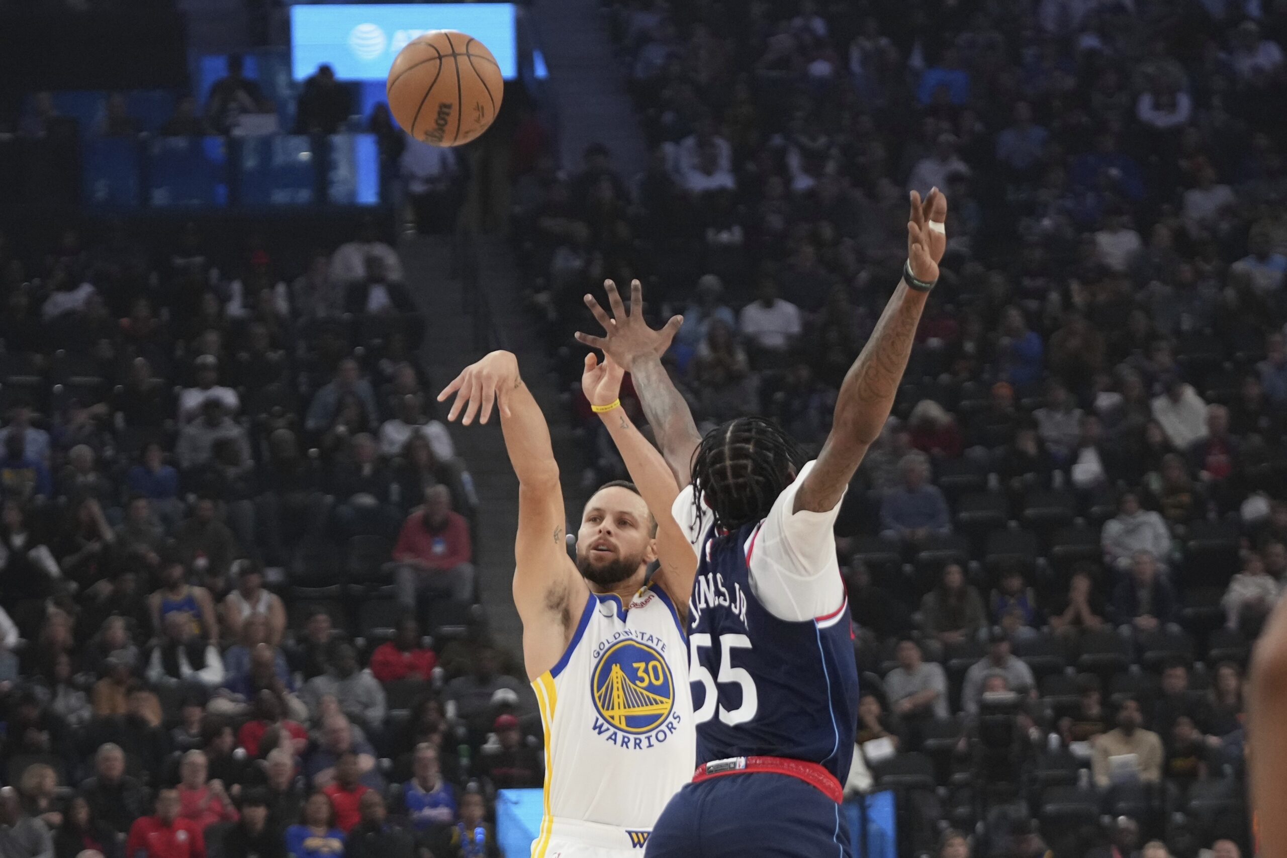 Golden State Warriors guard Steph Curry, left shoots as Clippers...