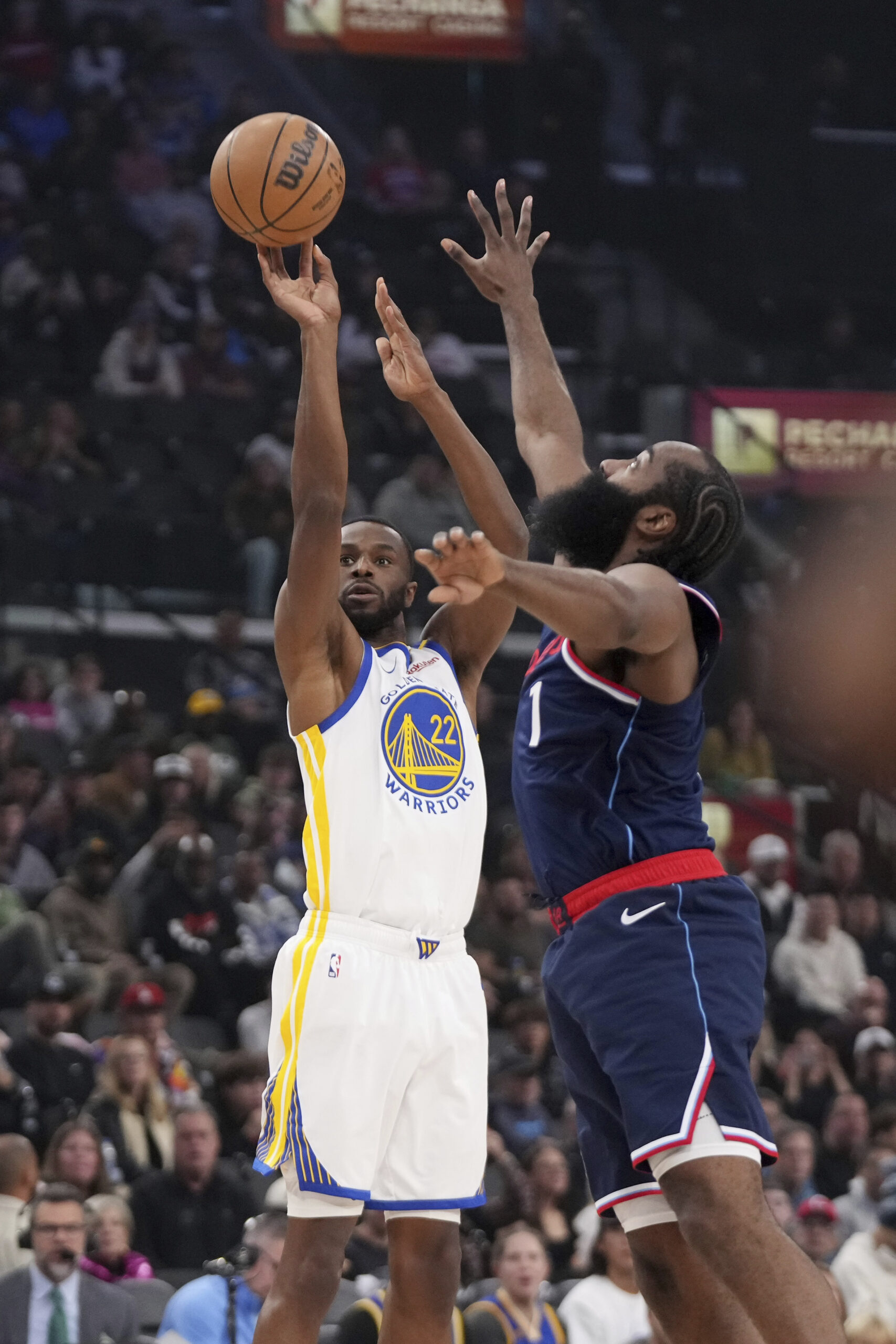 Golden State Warriors forward Andrew Wiggins, left, shoots as Clippers...