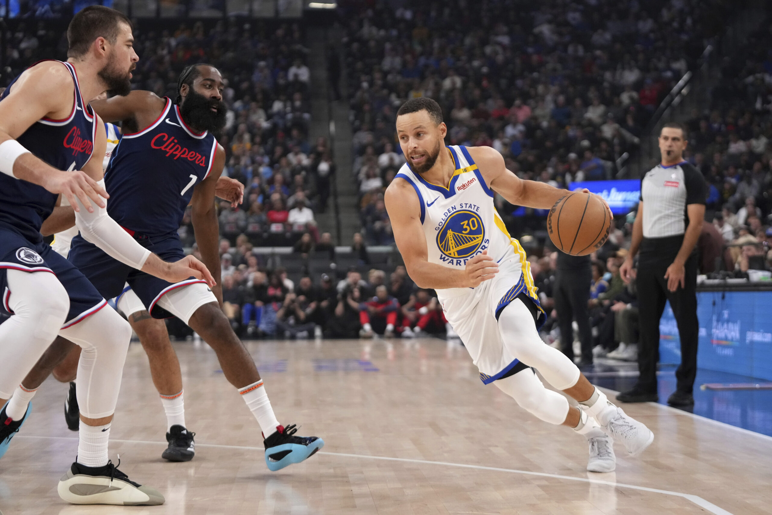 Golden State Warriors guard Steph Curry, right, drives past Clippers...