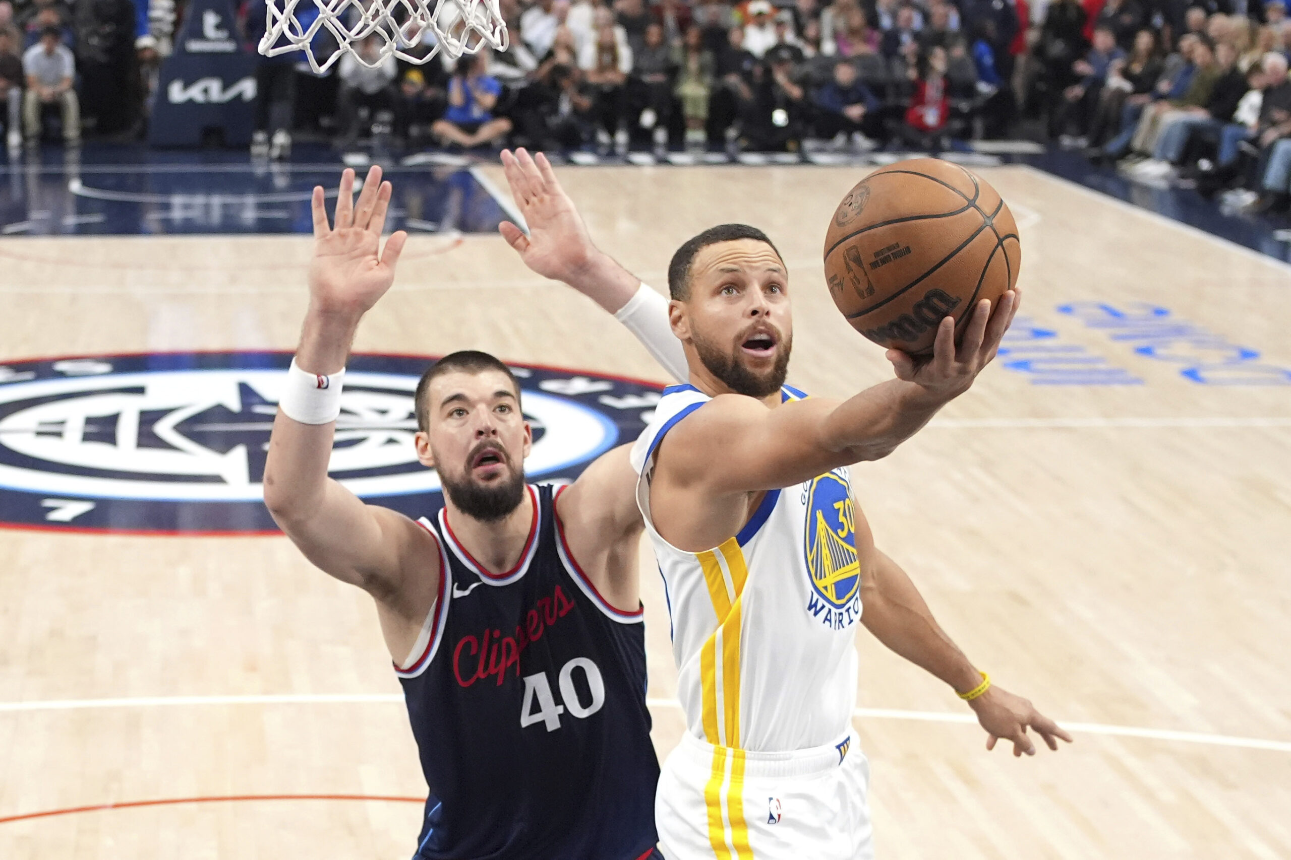 Golden State Warriors guard Steph Curry, right, shoots as Clippers...