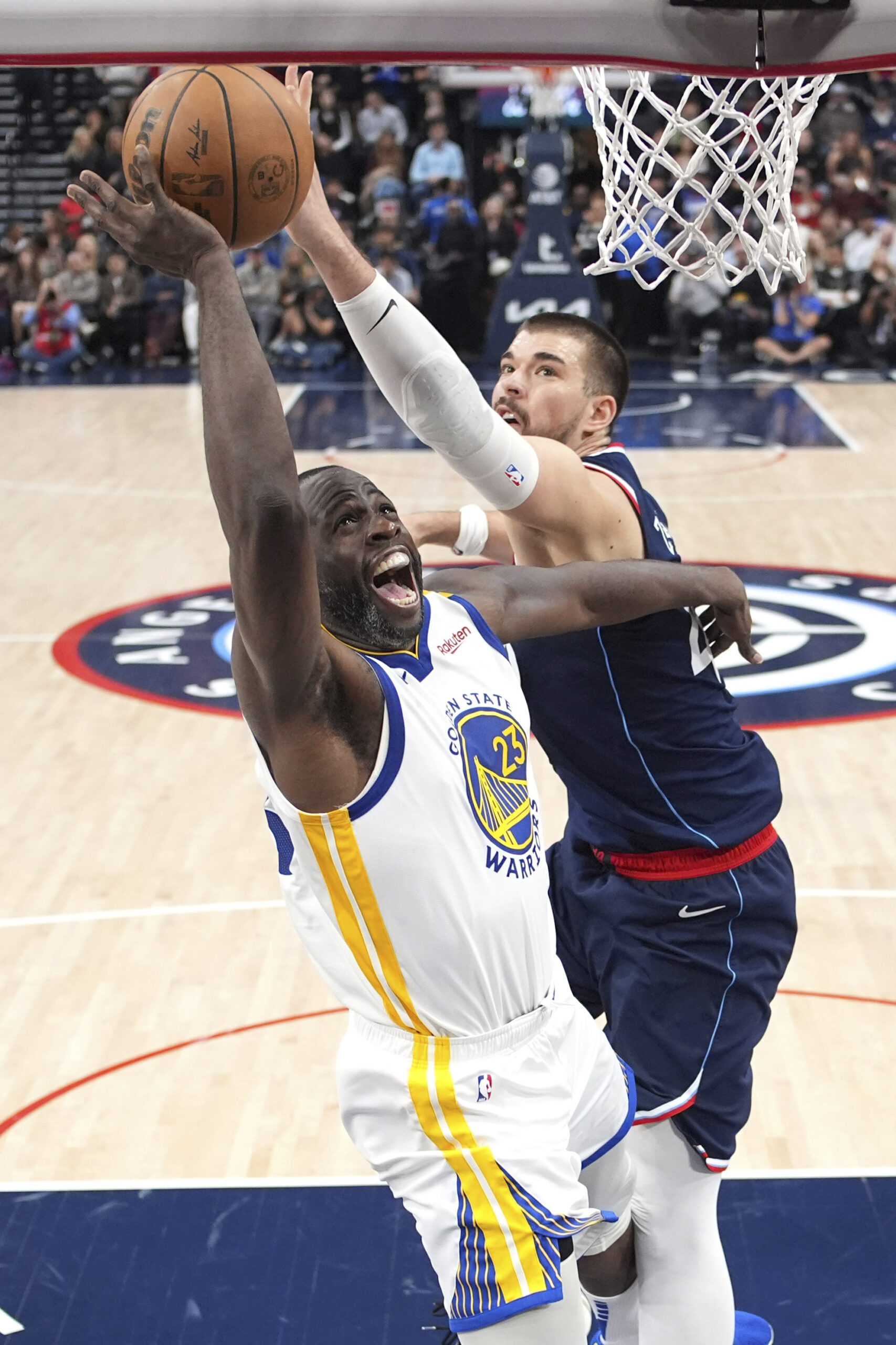 Golden State Warriors forward Draymond Green, left, shoots as Clippers...