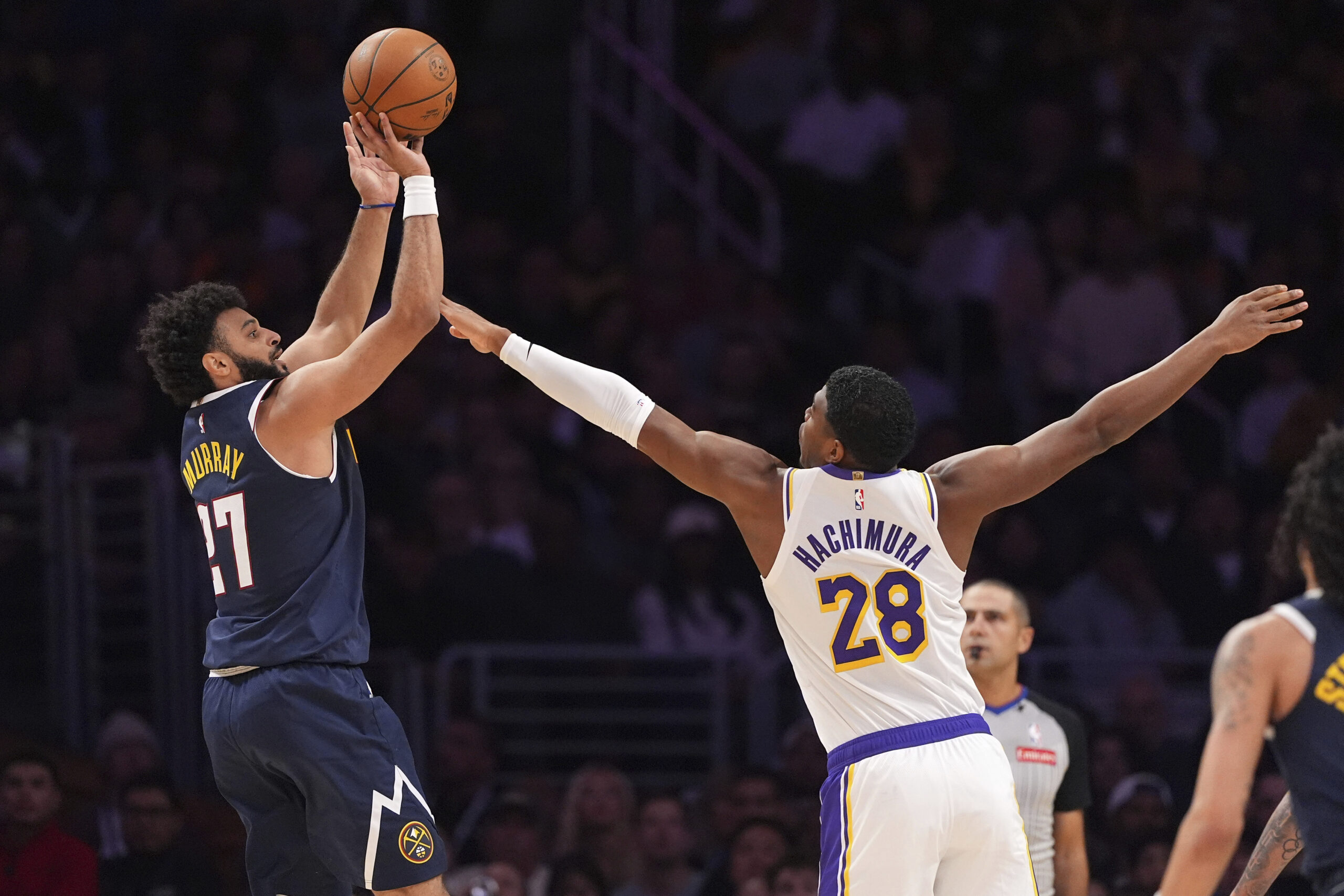 Denver Nuggets guard Jamal Murray, left, shoots as Lakers forward...