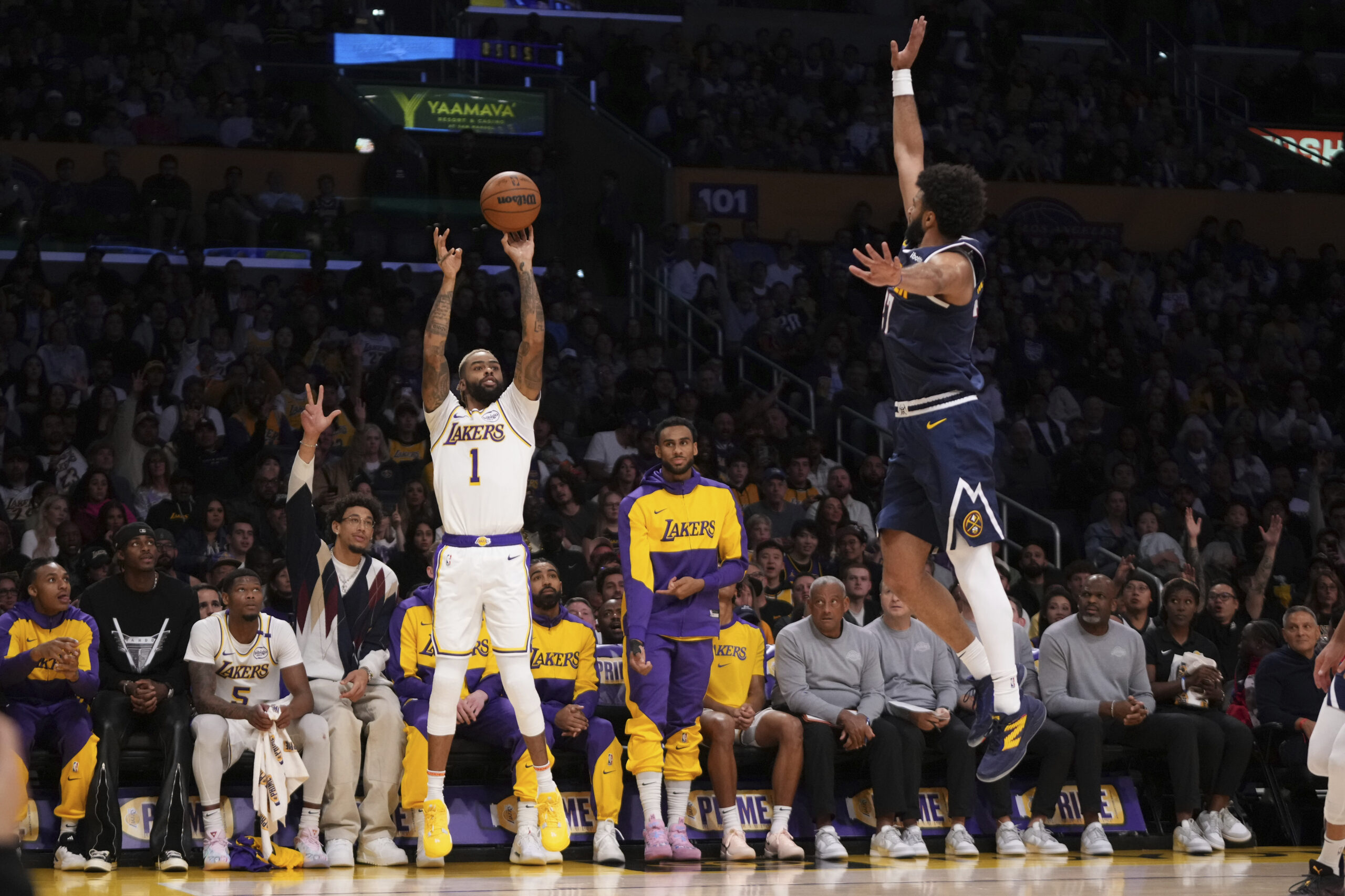 Lakers guard D’Angelo Russell, left, shoots as Denver Nuggets guard...