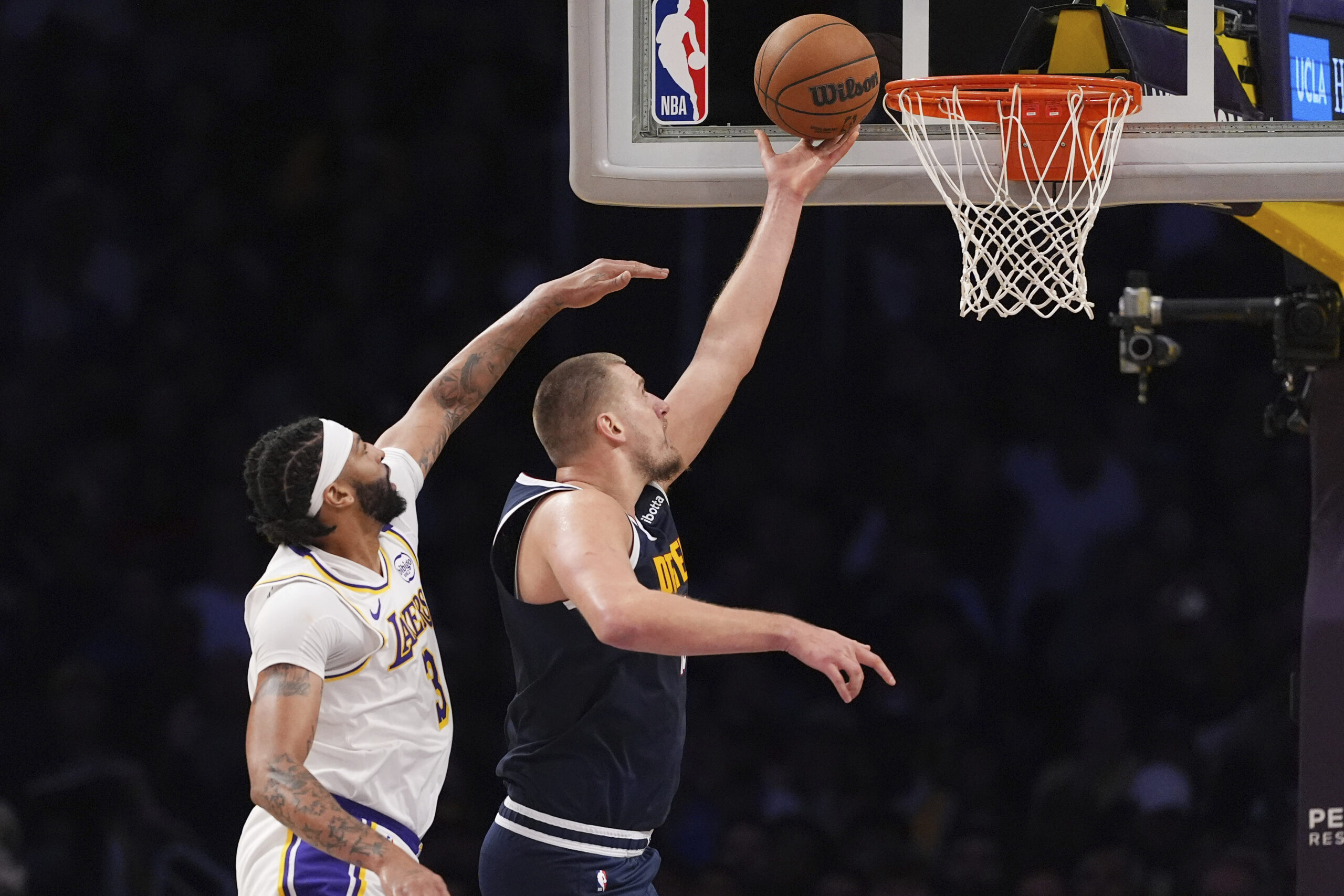 Denver Nuggets center Nikola Jokic, right, shoots as Lakers forward...