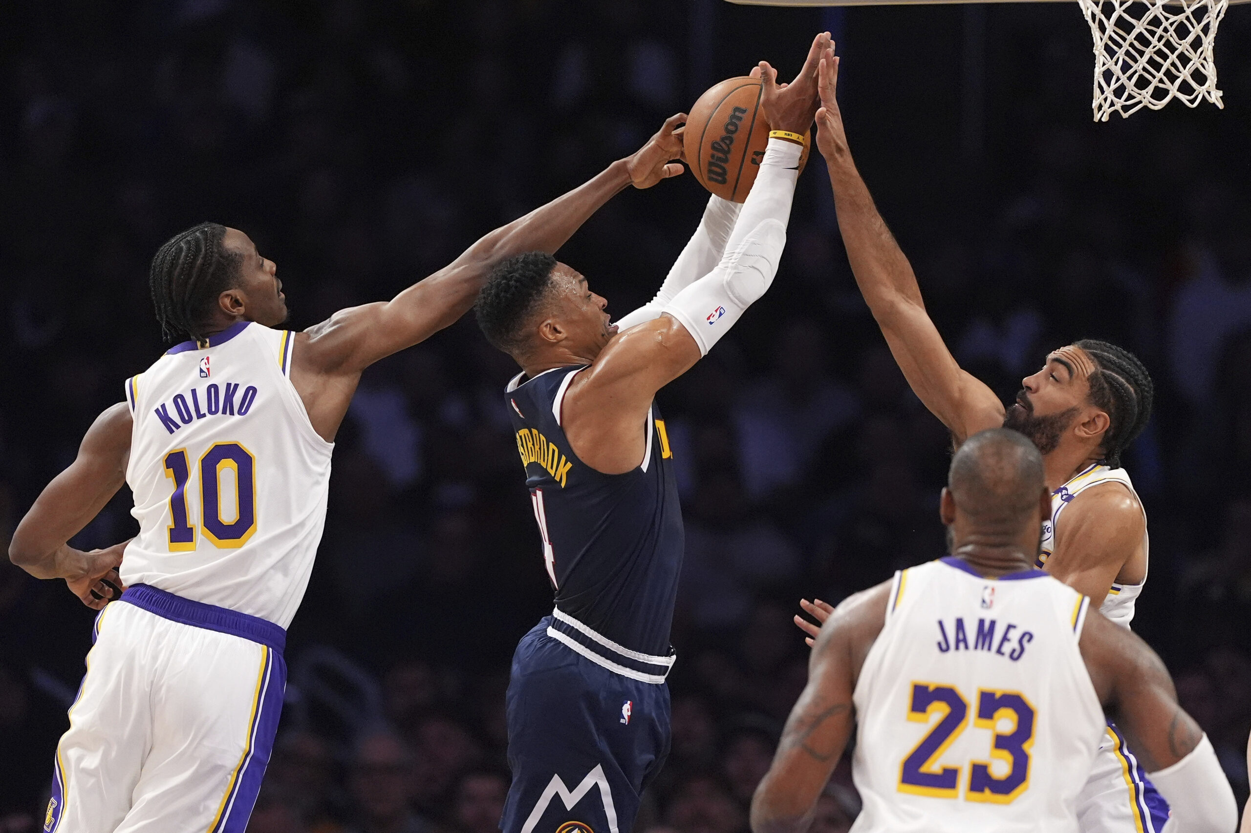 Denver Nuggets guard Russell Westbrook, second from left, tries to...