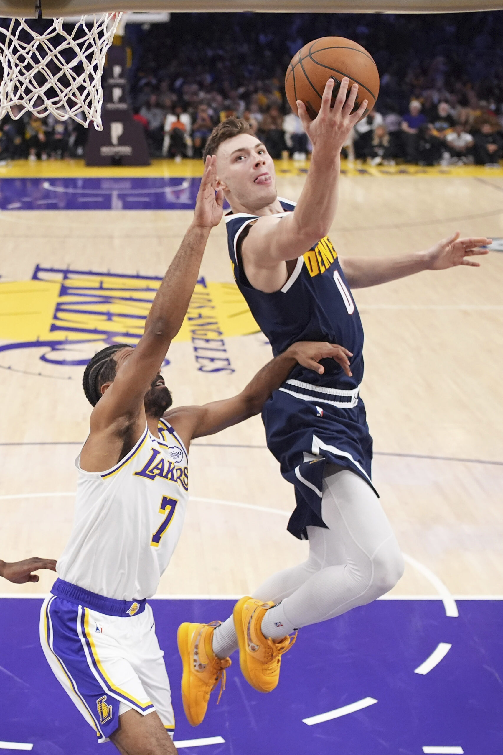 Denver Nuggets guard Christian Braun, right, shoots as Lakers guard...