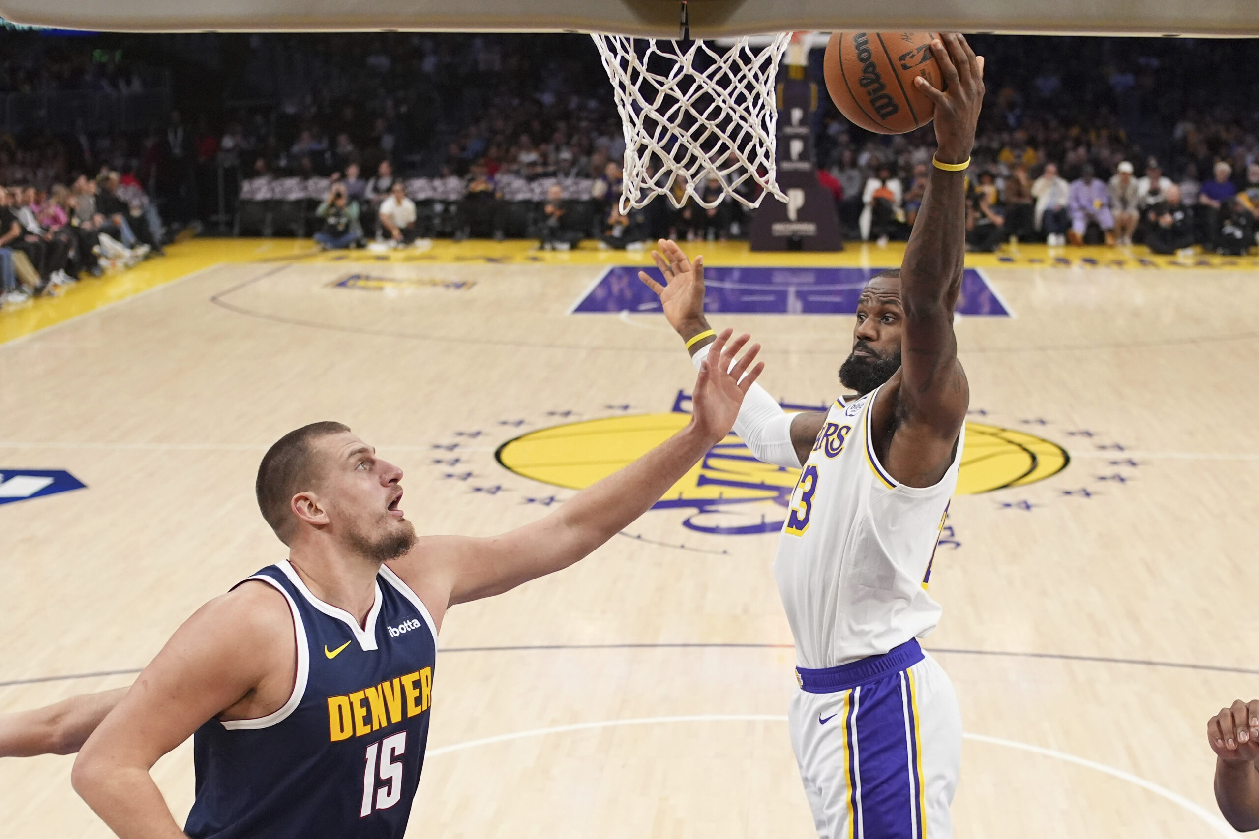 Lakers forward LeBron James, right, grabs a rebound away from...