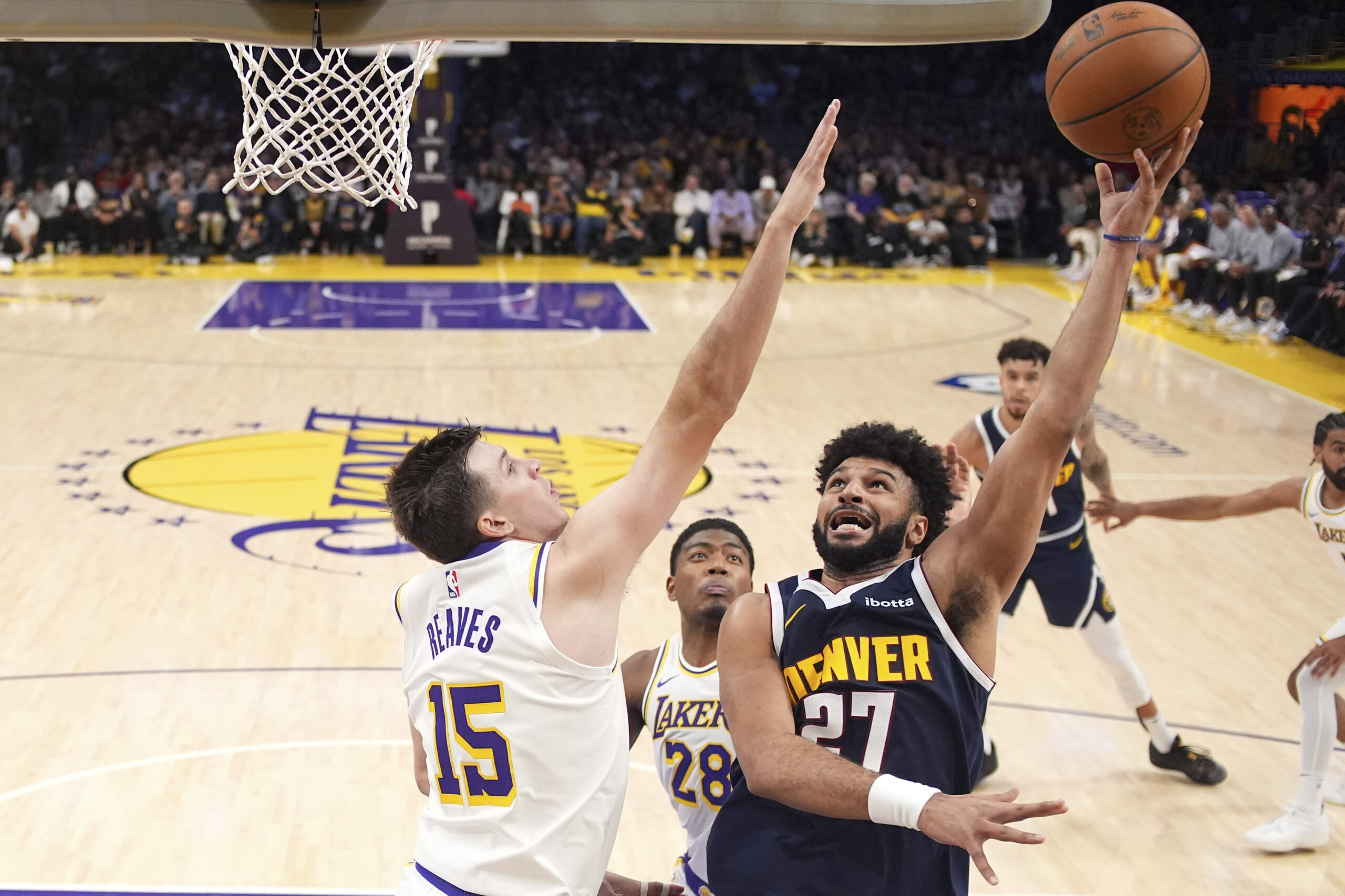 Denver Nuggets guard Jamal Murray, right, shoots as Lakers guard...