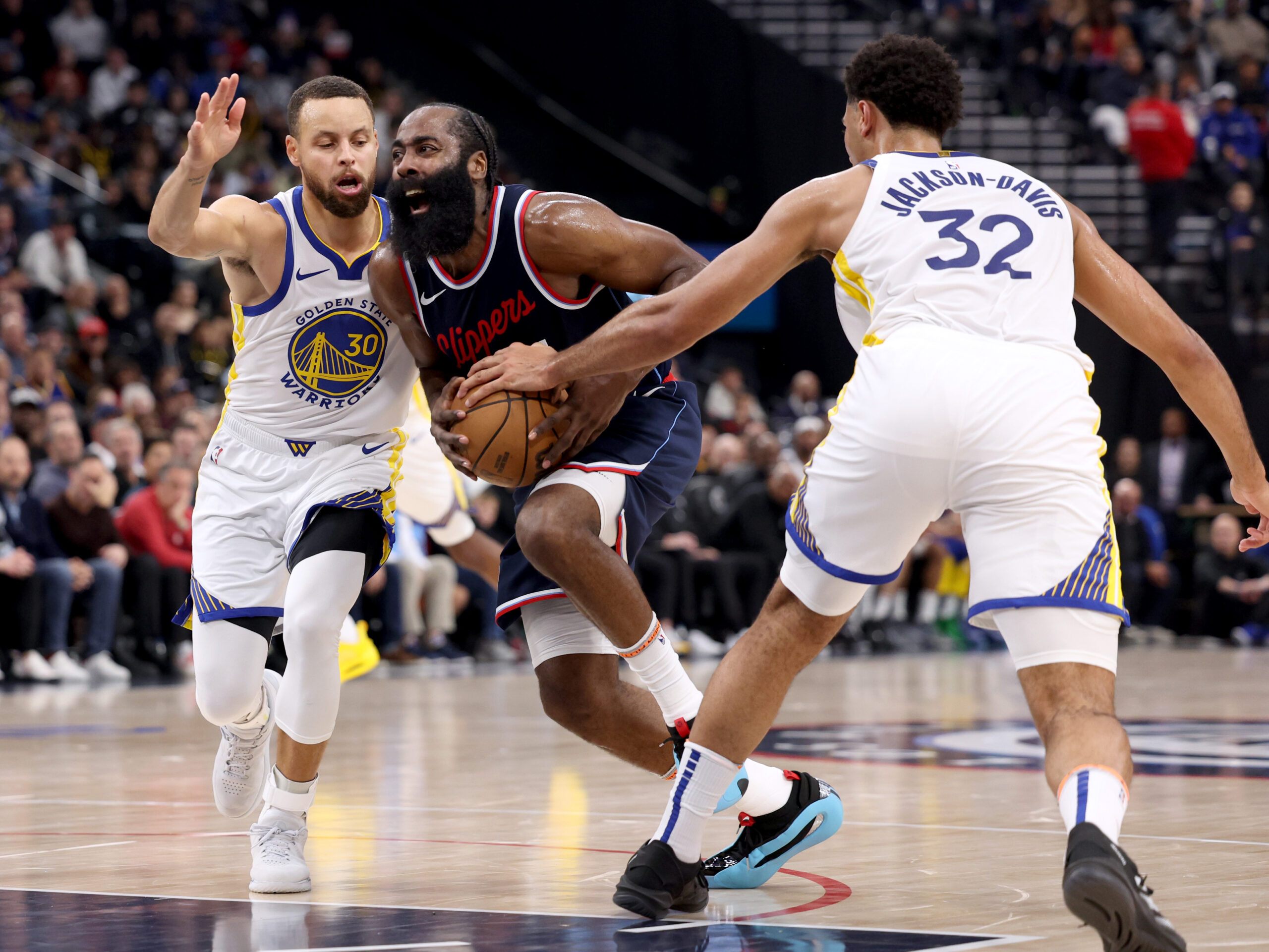 Clippers guard James Harden drives between Golden State Warriors guard...