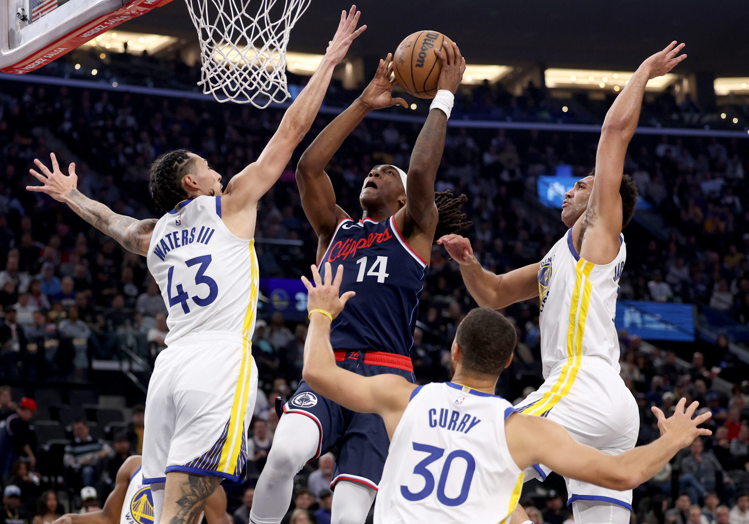 Clippers guard Terance Mann, center, scores between the Golden State...