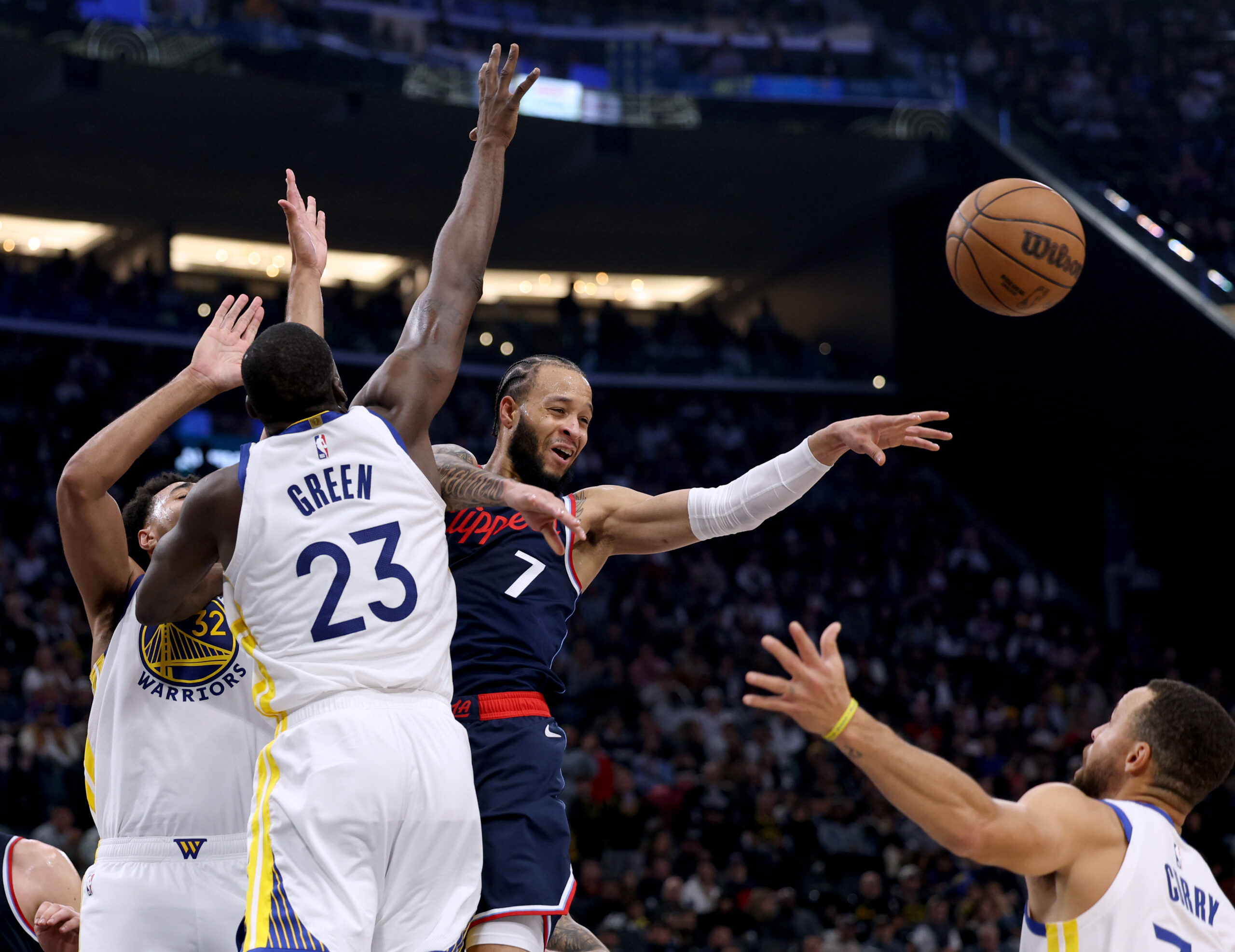 Clippers guard Amir Coffey, center, passes the ball away from...