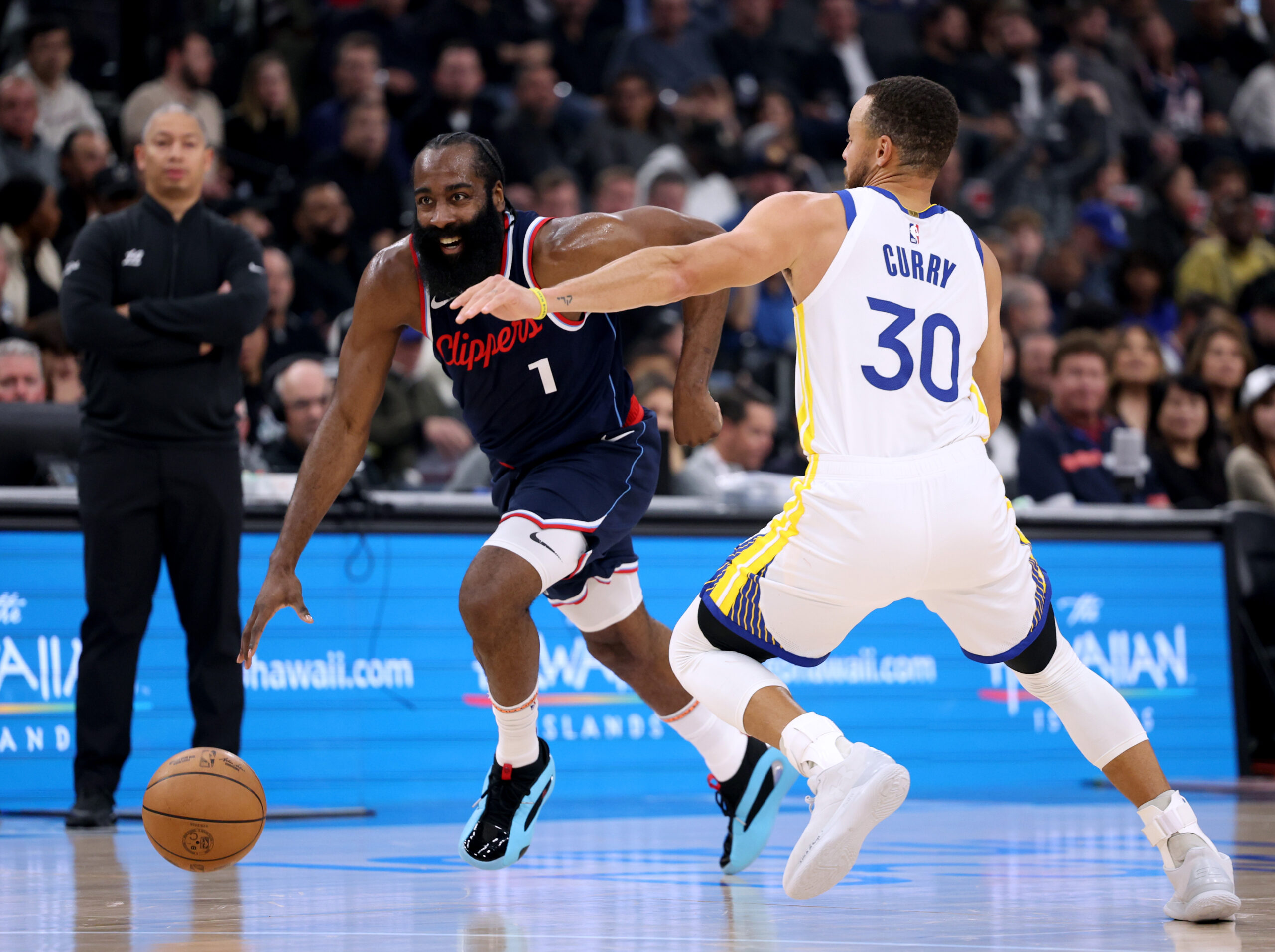 Clippers guard James Harden drives to the basket as Golden...