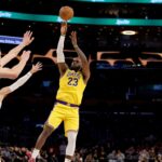 Los Angeles Lakers forward LeBron James (23) shoots the ball over defenders’ outstretched hands