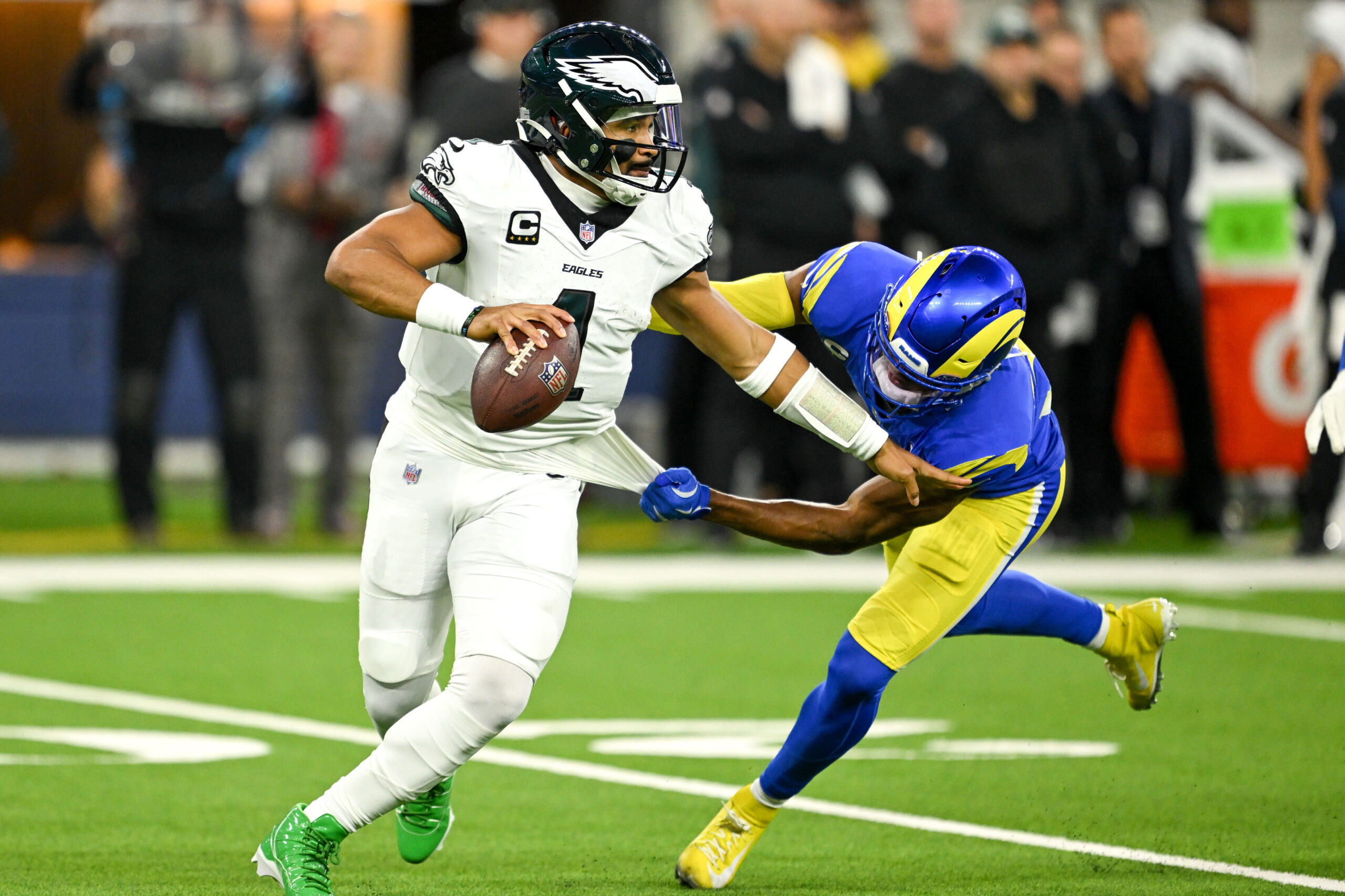 Eagles QB Jalen Hurts, #1, gets pressure from Rams Quentin...