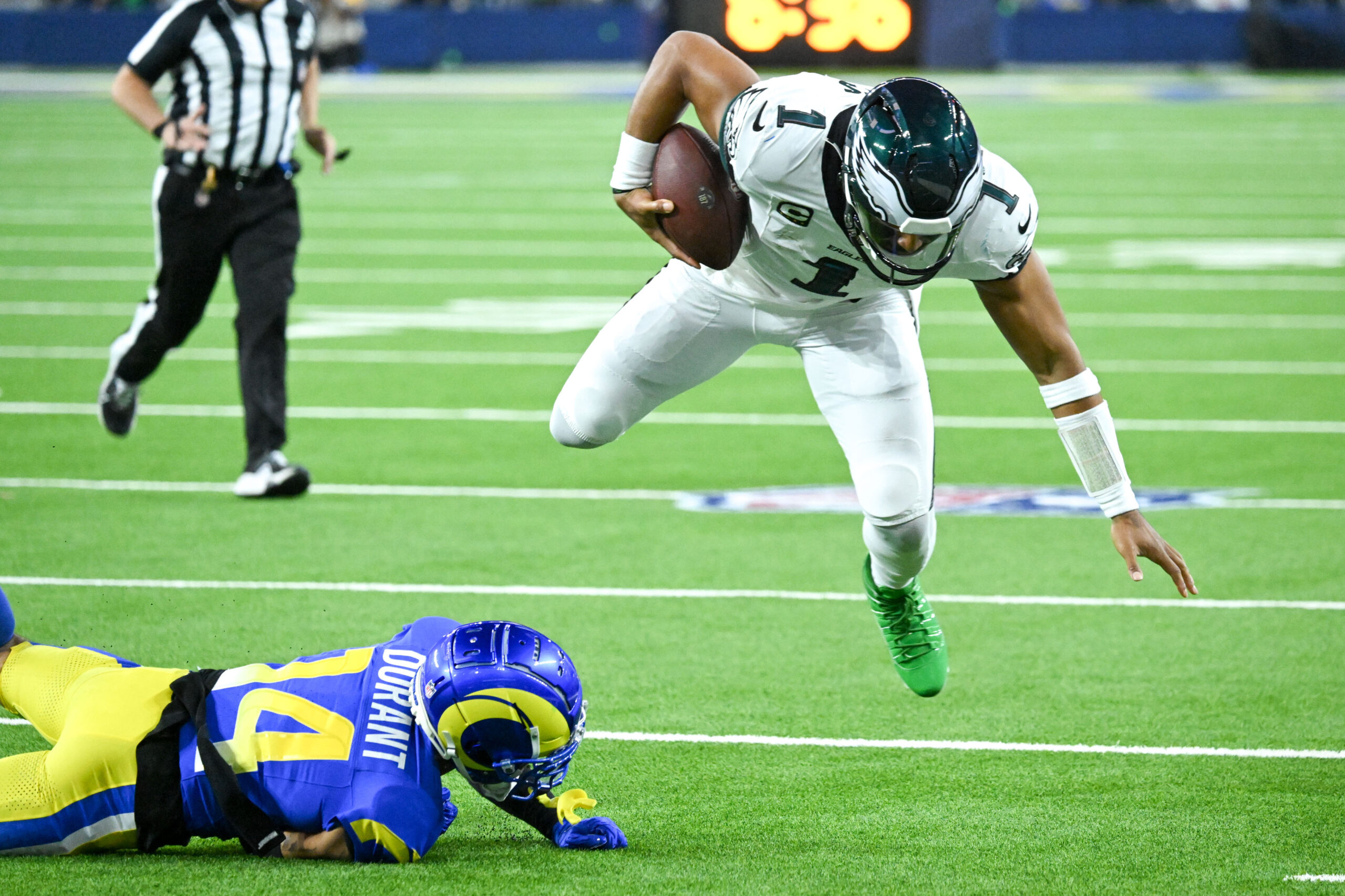 Eagles QB Jalen Hurts, #1, jumps over Rams Decobie Durant,...