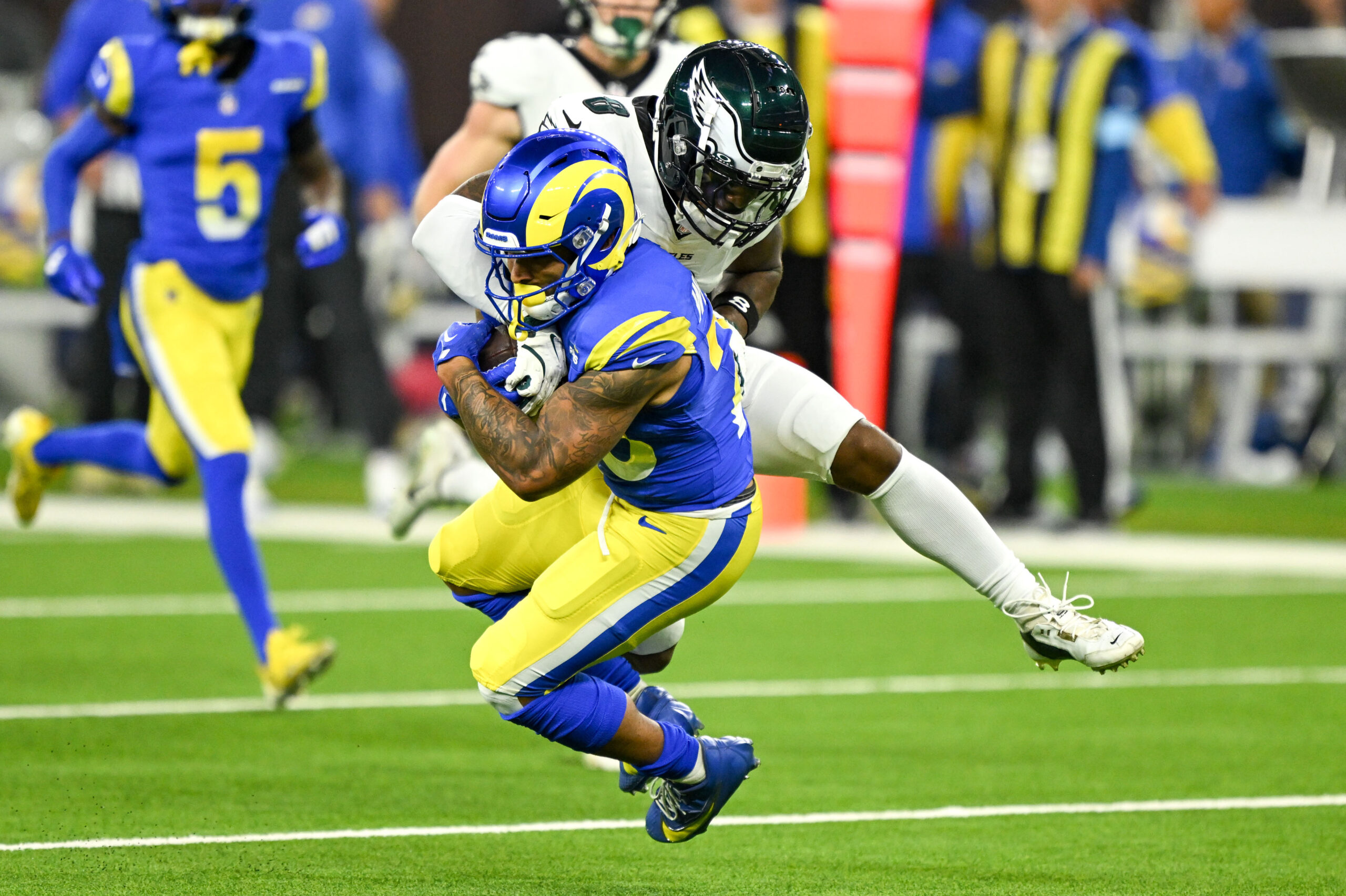 Rams Kyren Williams, #23, gets pulled down by. Eagles Chauncey...