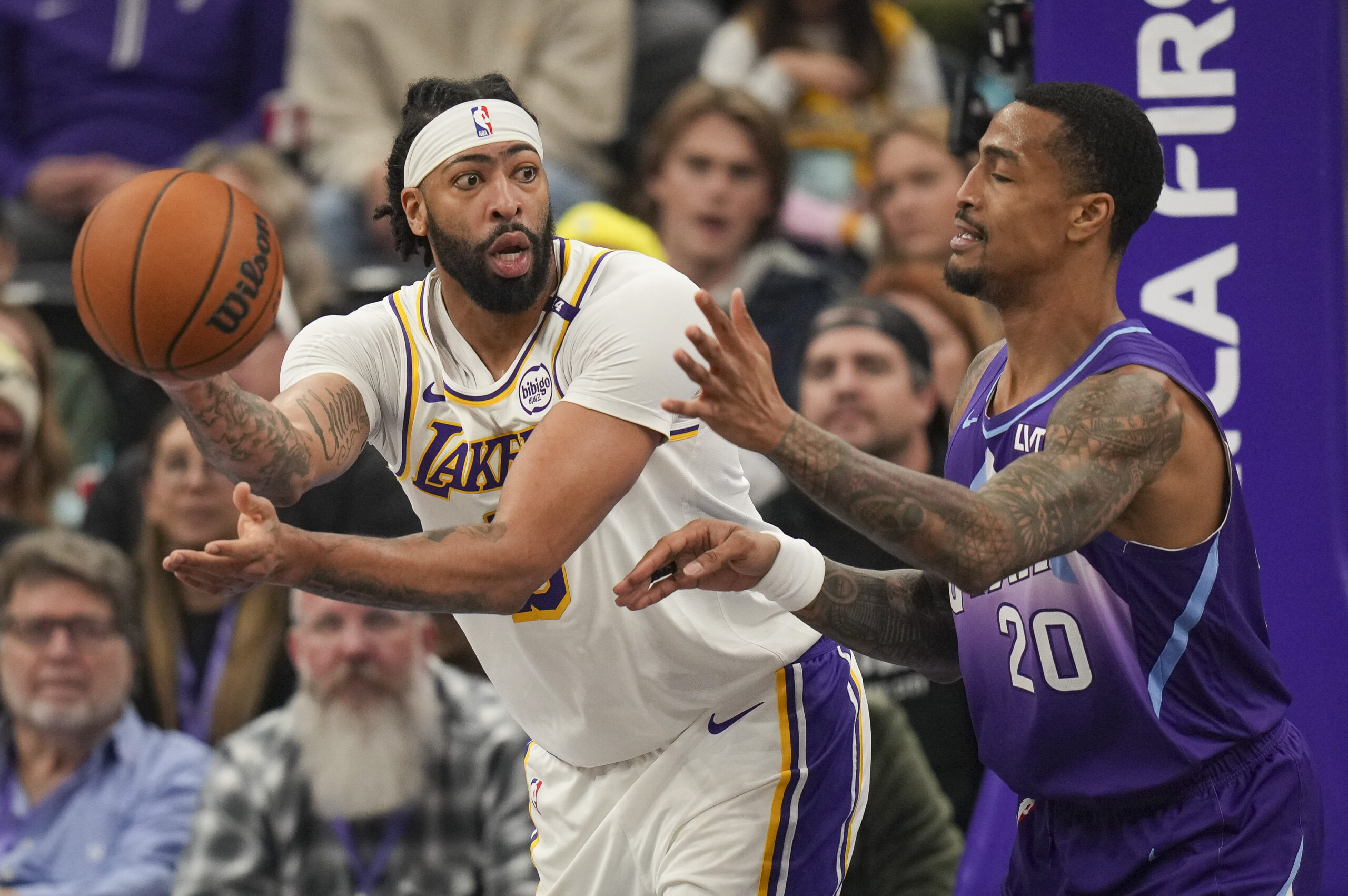 Lakers forward Anthony Davis, left, passes the ball around Utah...