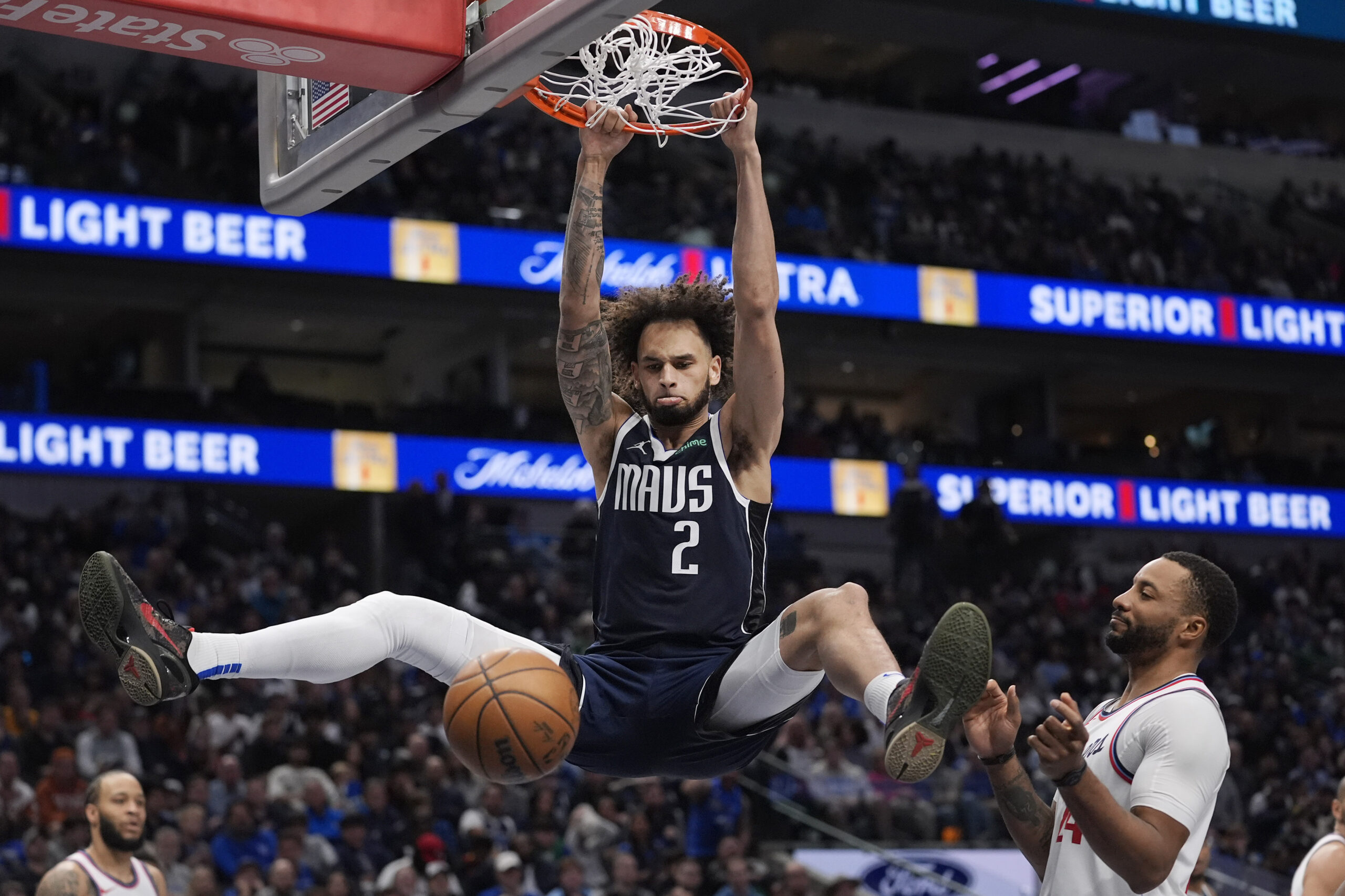 Dallas Mavericks center Dereck Lively II (2) hangs from the...