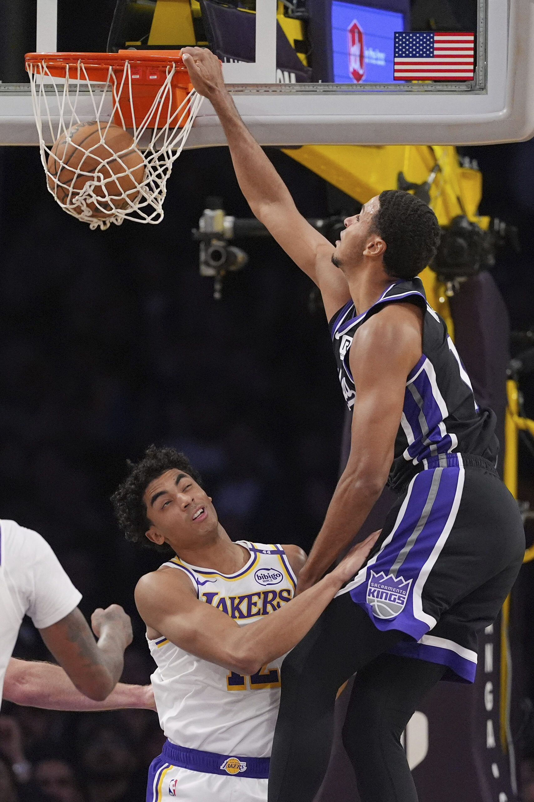 Sacramento Kings forward Keegan Murray, right, dunks over Lakers guard...