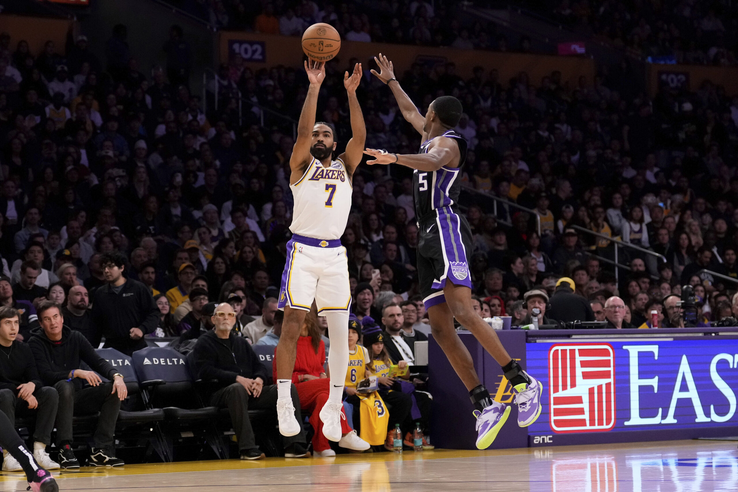 Lakers guard Gabe Vincent, left, shoots as Sacramento Kings guard...