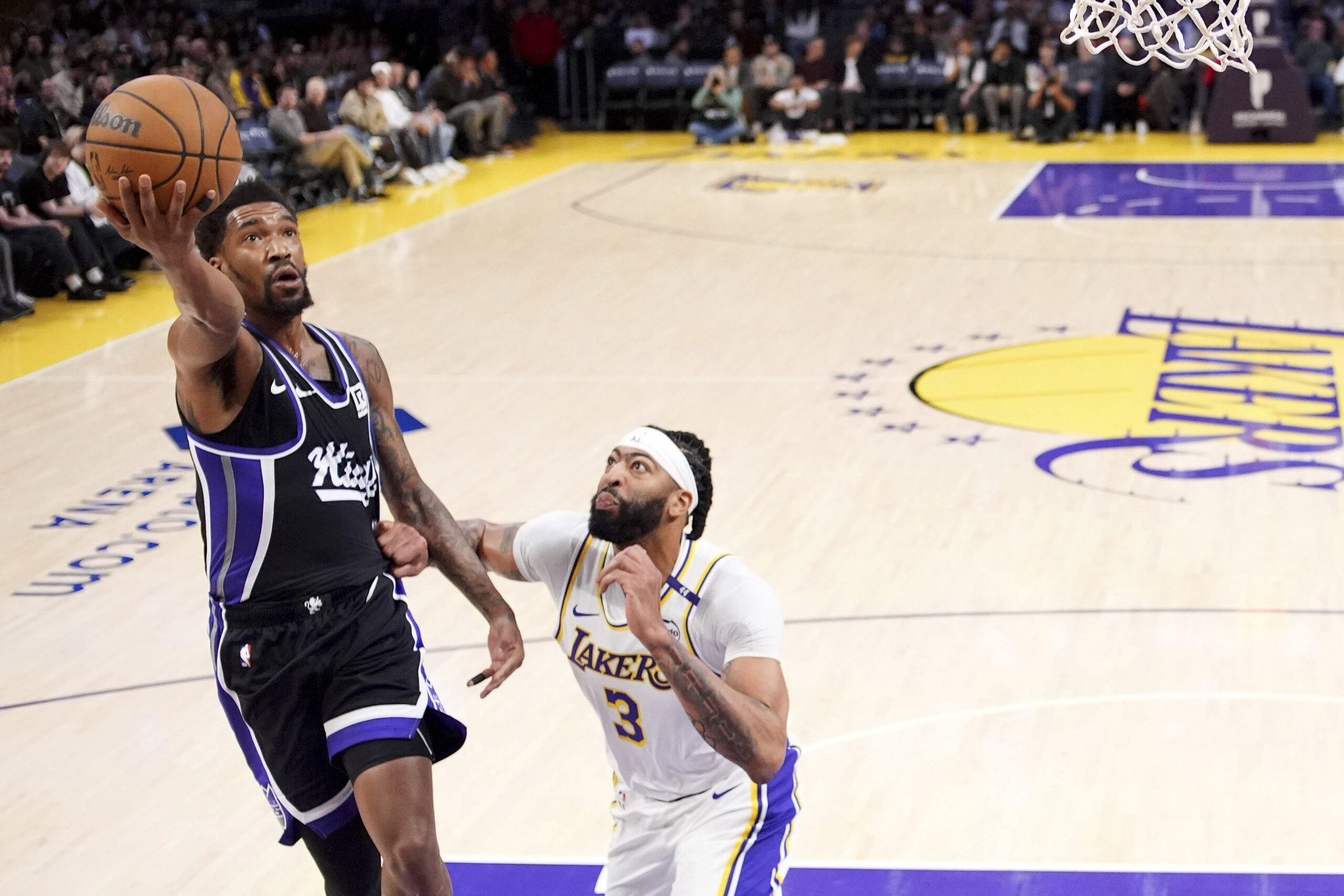 Sacramento Kings guard Malik Monk, left, shoots as Lakers forward...