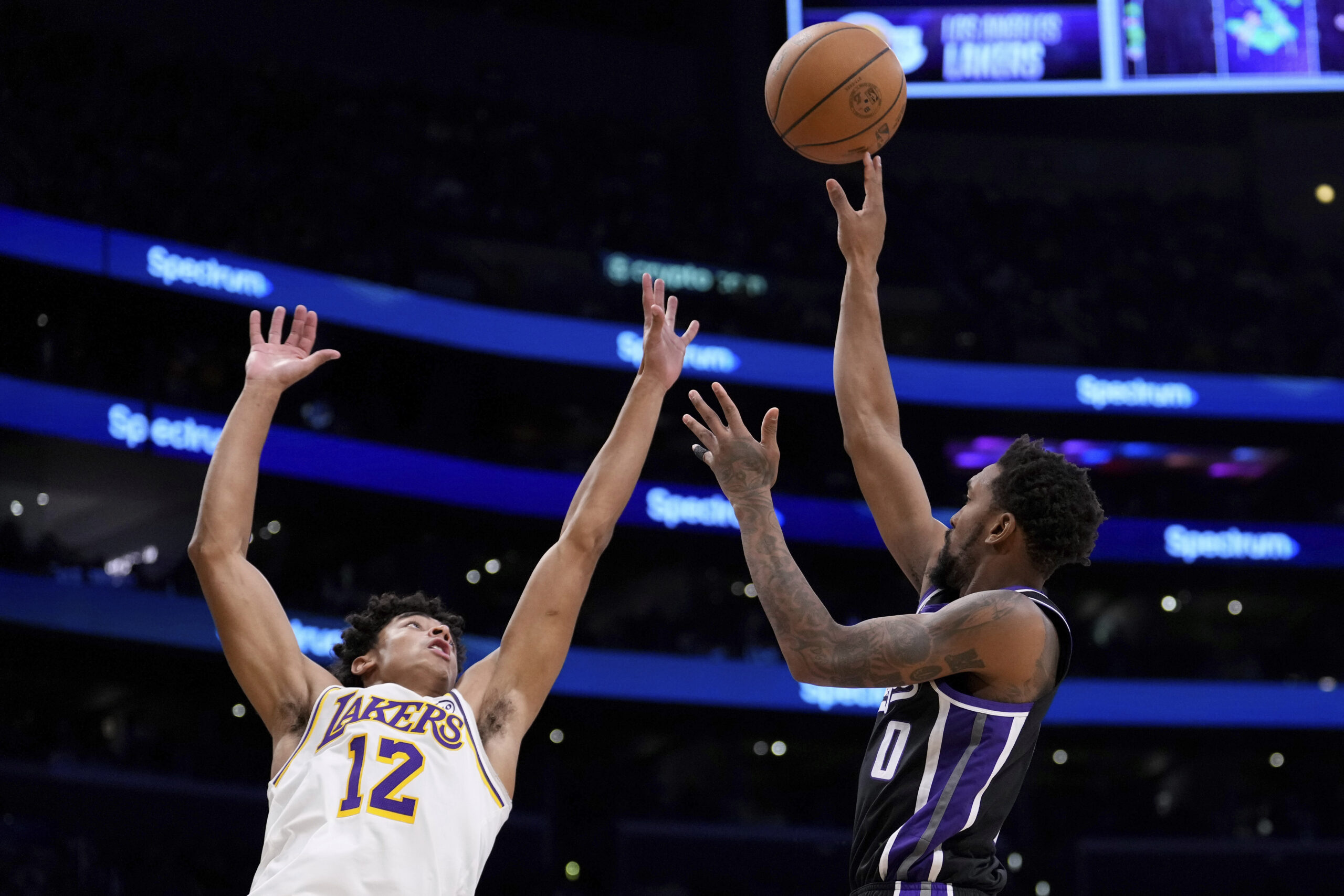 Sacramento Kings guard Malik Monk, right, shoots as Lakers guard...