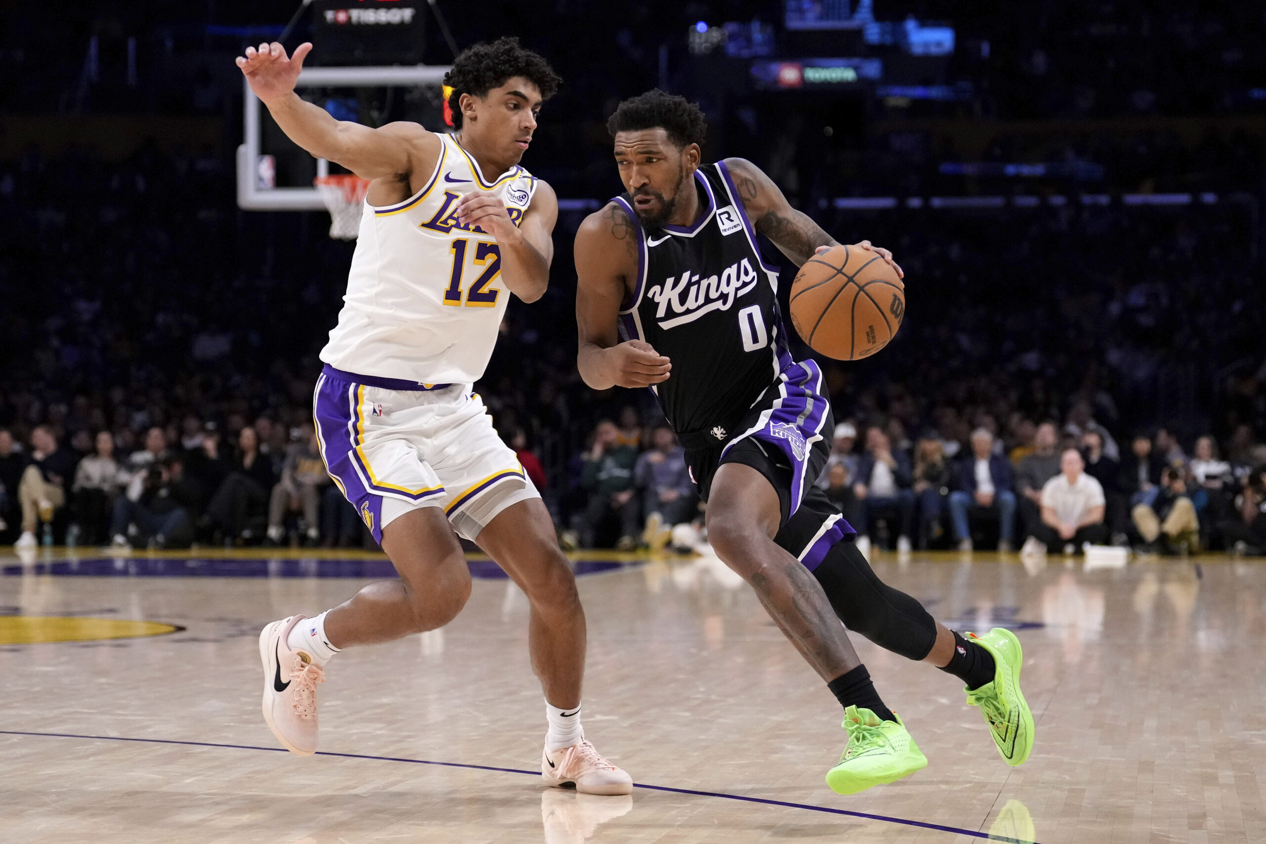 Sacramento Kings guard Malik Monk, right, drives past Lakers guard...