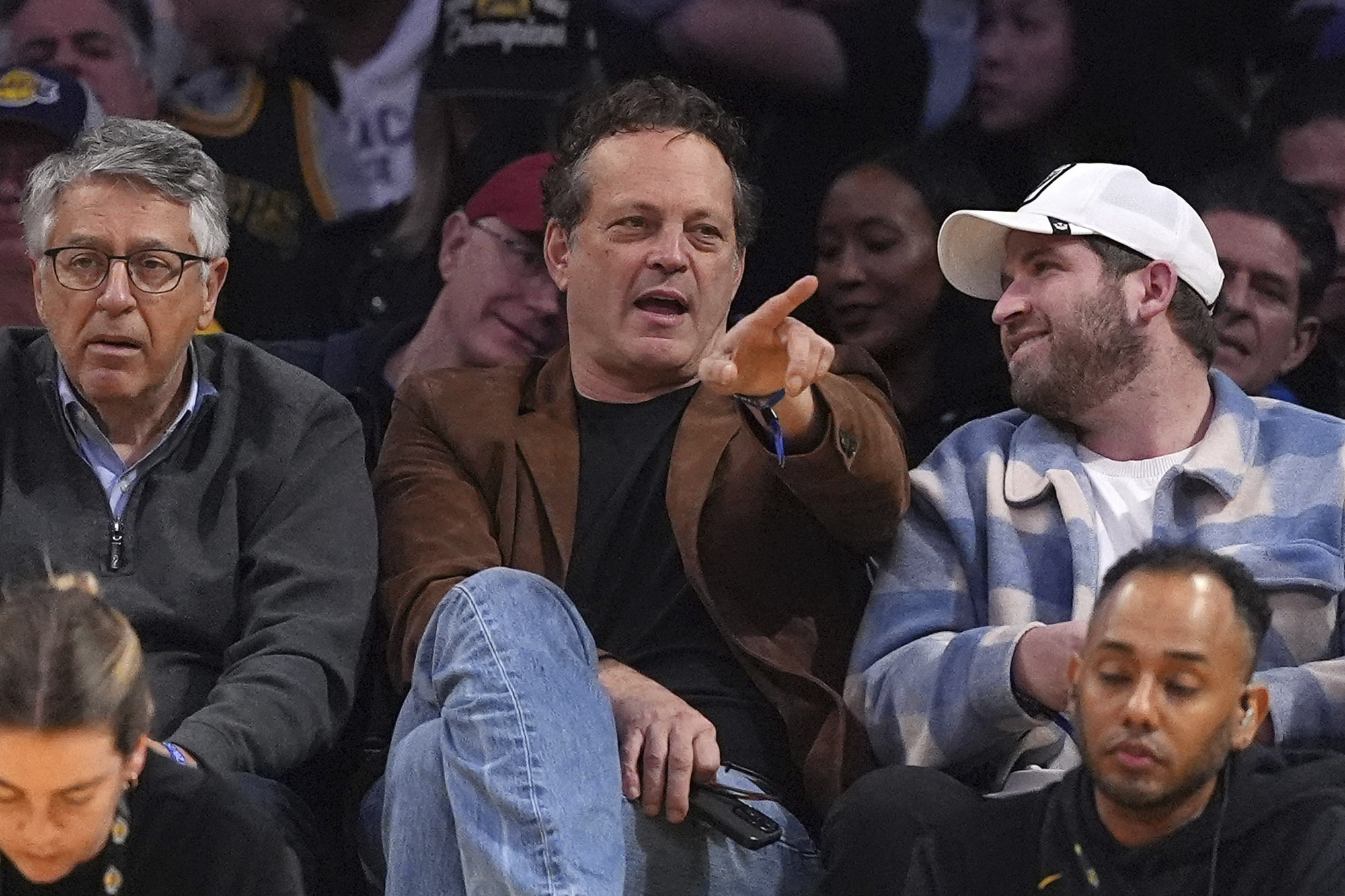 Actor Vince Vaughn, center, watches during the second half of...