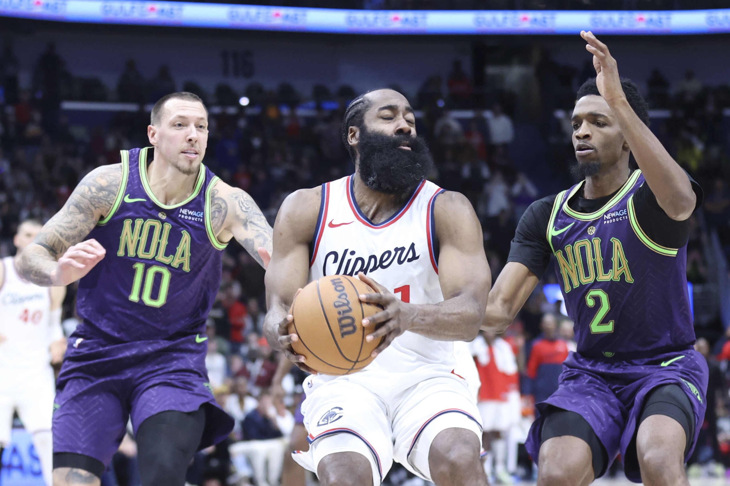 Clippers guard James Harden grabs a loose ball while being...