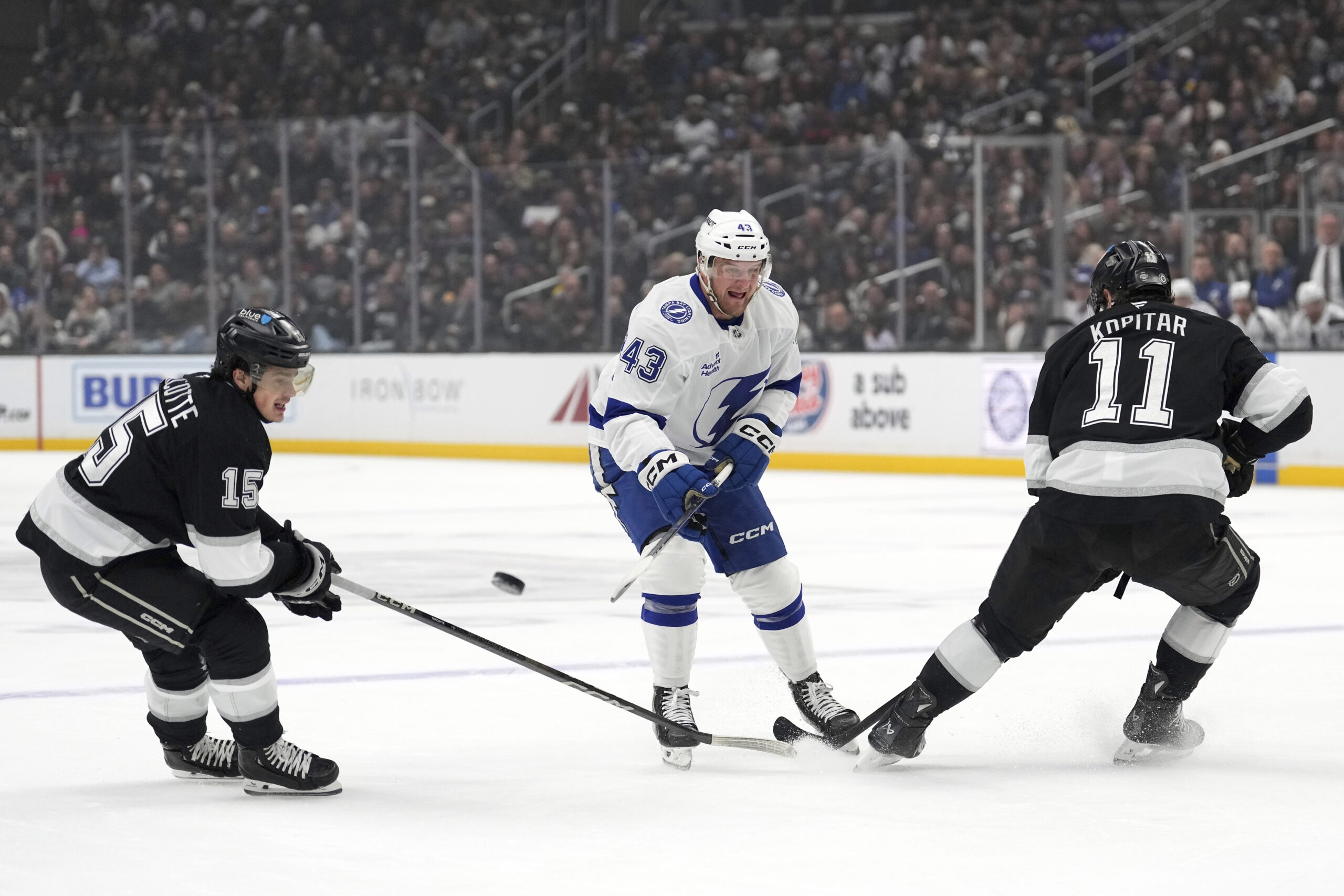 Tampa Bay Lightning defenseman Darren Raddysh, center, passes the puck...