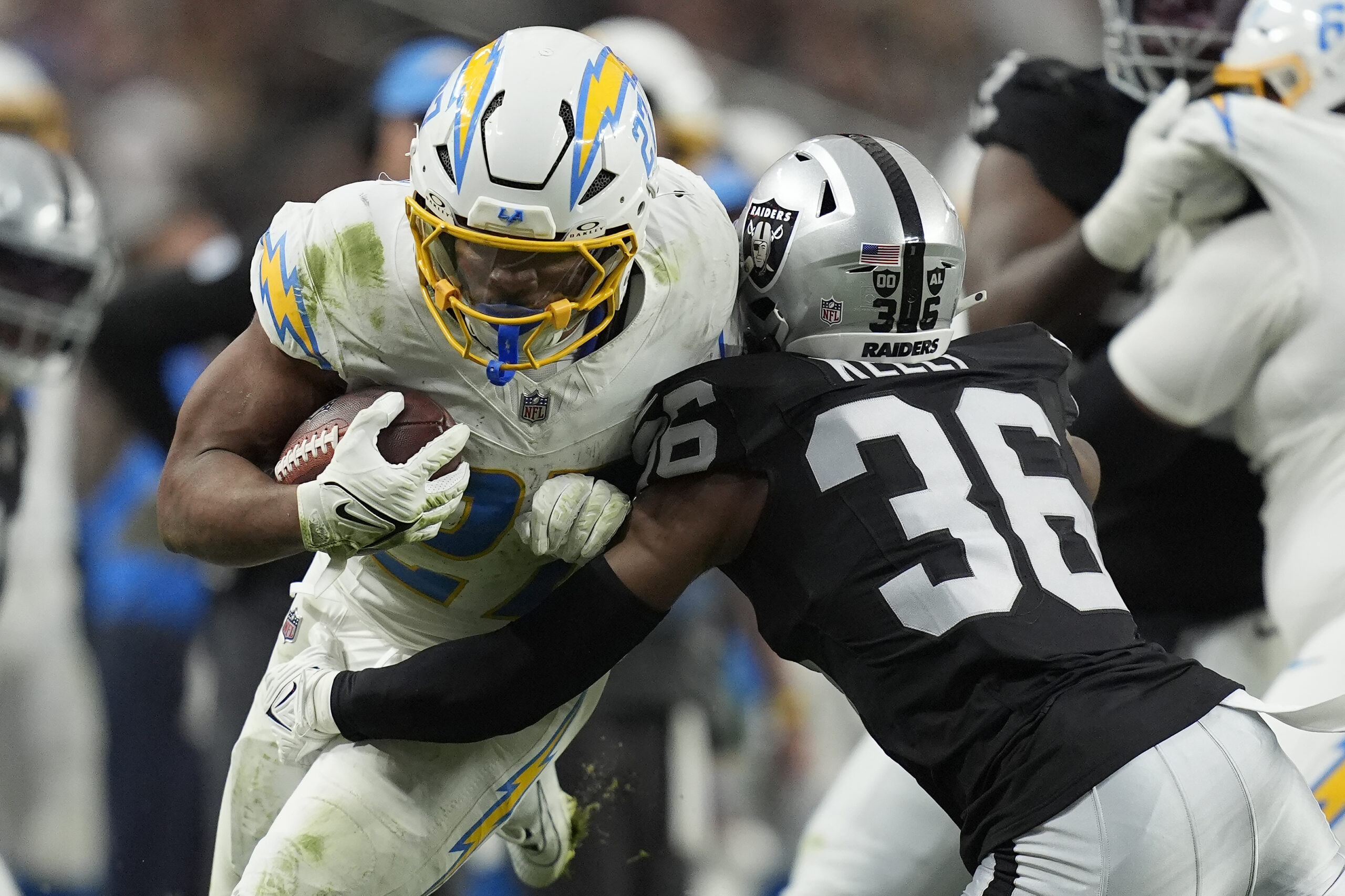 Los Angeles Chargers running back J.K. Dobbins, left, runs against...