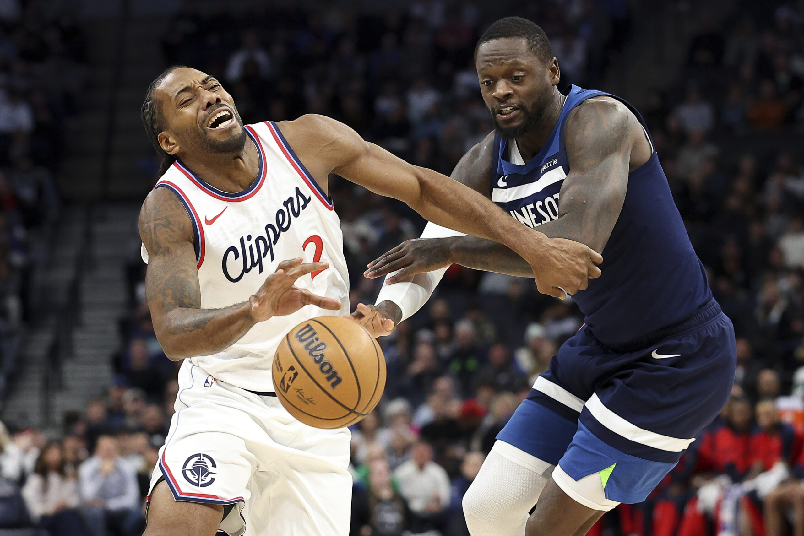 Clippers forward Kawhi Leonard, left, tries to drive around Minnesota...