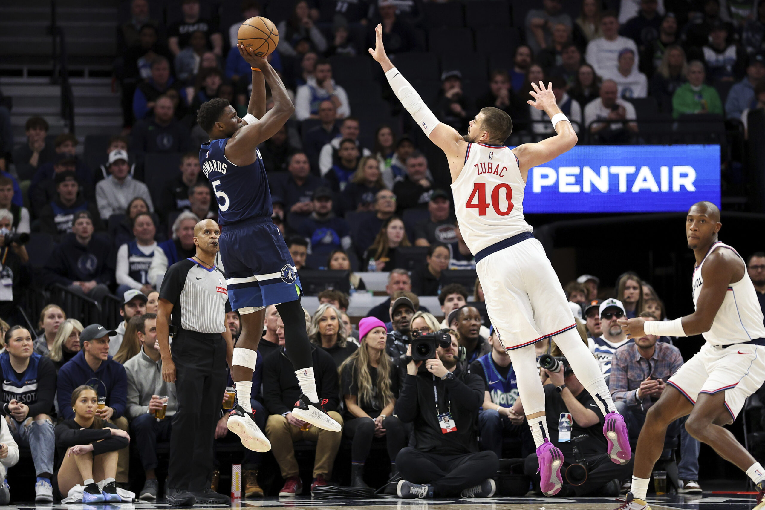 Minnesota Timberwolves guard Anthony Edwards, left, shoots from outside as...