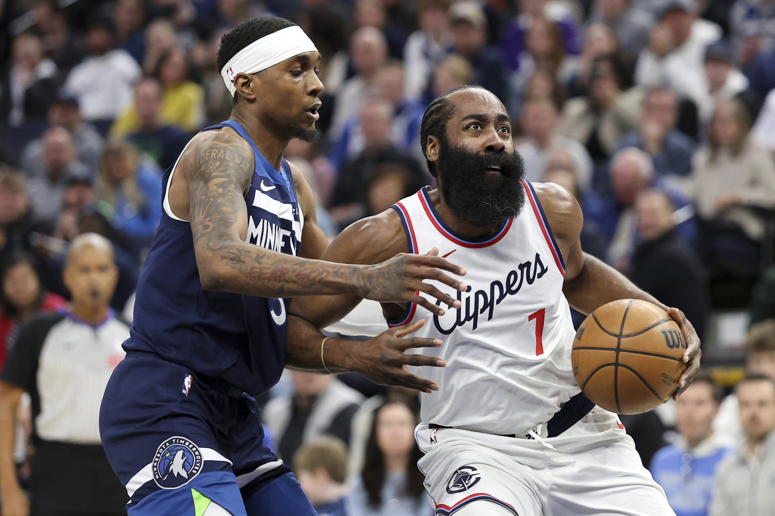 Clippers guard James Harden, right, drives toward the basket as...