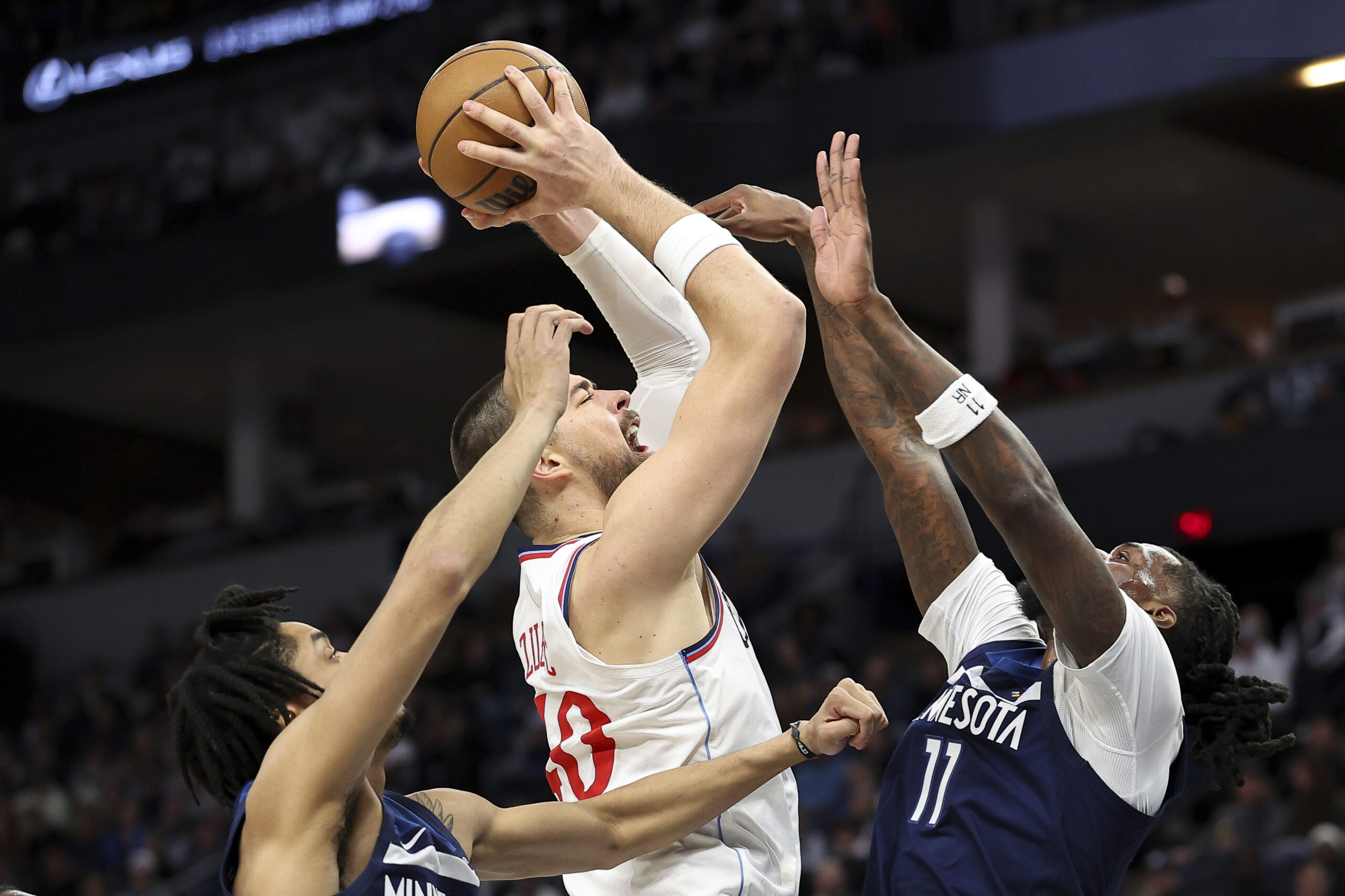 Clippers center Ivica Zubac, center, looks to shoot as Minnesota...